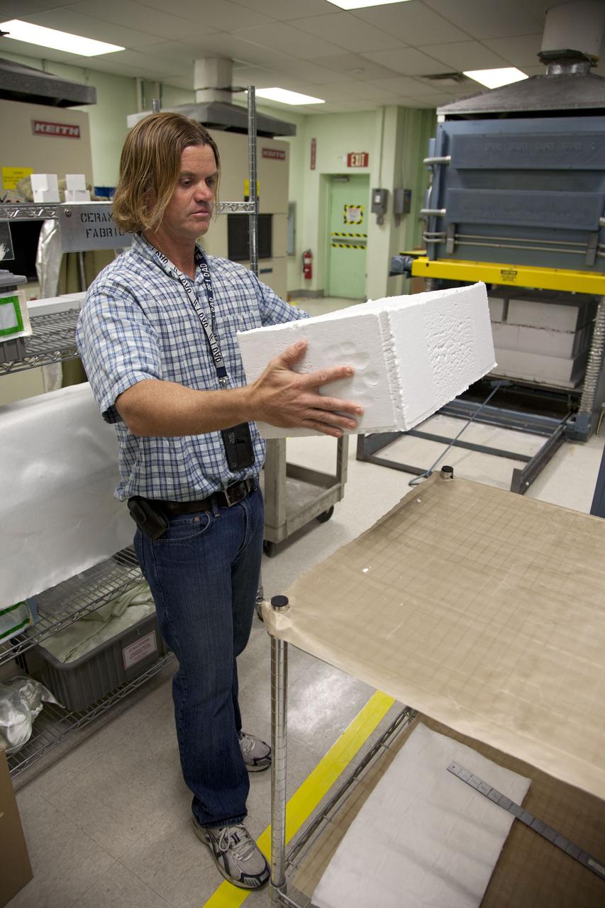 Tim Wright, a United Space Alliance engineering manager at NASA's Kennedy Space Center in Florida, unpacks the heat shield tiles that will be installed to the backshell of the Orion Multi-Purpose Crew Vehicle's Exploration Flight Test EFT-1 capsule. The tiles are being manufactured and inspected in Kennedy's Thermal Protection System Facility. The tiles will be baked at 2,200 degrees F to cure their ceramic coating. EFT-1 will be used during Orion's first test flight in space. For more information, visit www.nasa.gov/orion. Photo credit: Frankie Martin