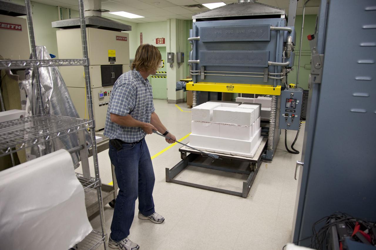 CAPE CANAVERAL, Fla. -- Tim Wright, a United Space Alliance engineering manager at NASA's Kennedy Space Center in Florida, unloads the heat shield tiles that will be installed to the backshell of the Orion Multi-Purpose Crew Vehicle's Exploration Flight Test EFT-1 capsule. The tiles are being manufactured and inspected in Kennedy's Thermal Protection System Facility. The tiles will be baked at 2,200 degrees F to cure their ceramic coating. EFT-1 will be used during Orion's first test flight in space. For more information, visit www.nasa.gov/orion. Photo credit: Frankie Martin