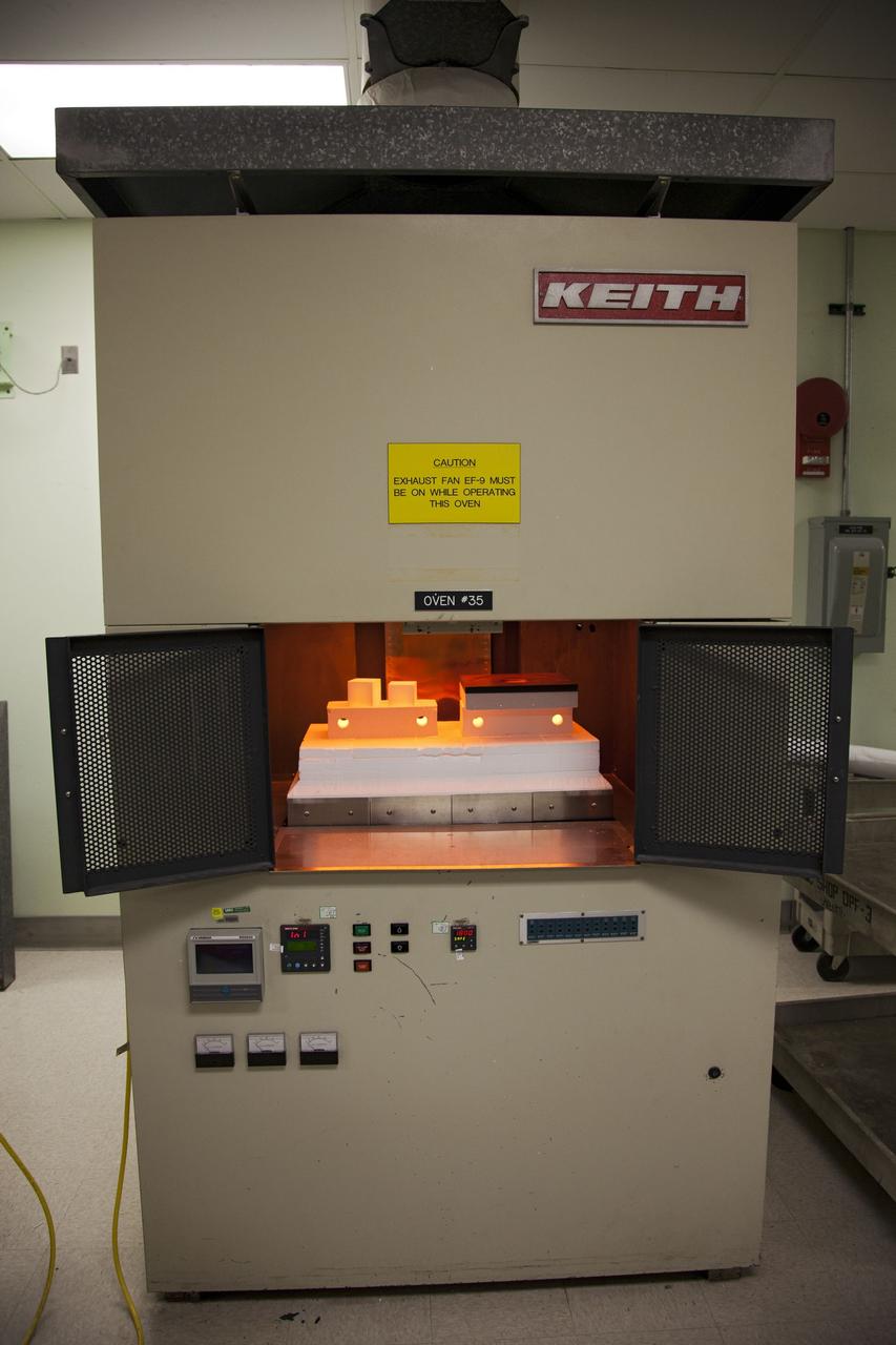 CAPE CANAVERAL, Fla. -- The heat shield tiles that will be installed to the backshell of the Orion Multi-Purpose Crew Vehicle's Exploration Flight Test EFT-1 capsule are in a Keith thermal automation oven in the Thermal Protection System Facility at NASA's Kennedy Space Center in Florida. Inside the oven, the tiles will be baked at 2,200 degrees F to cure their ceramic coating. EFT-1 will be used during Orion's first test flight in space. For more information, visit www.nasa.gov/orion. Photo credit: Frankie Martin