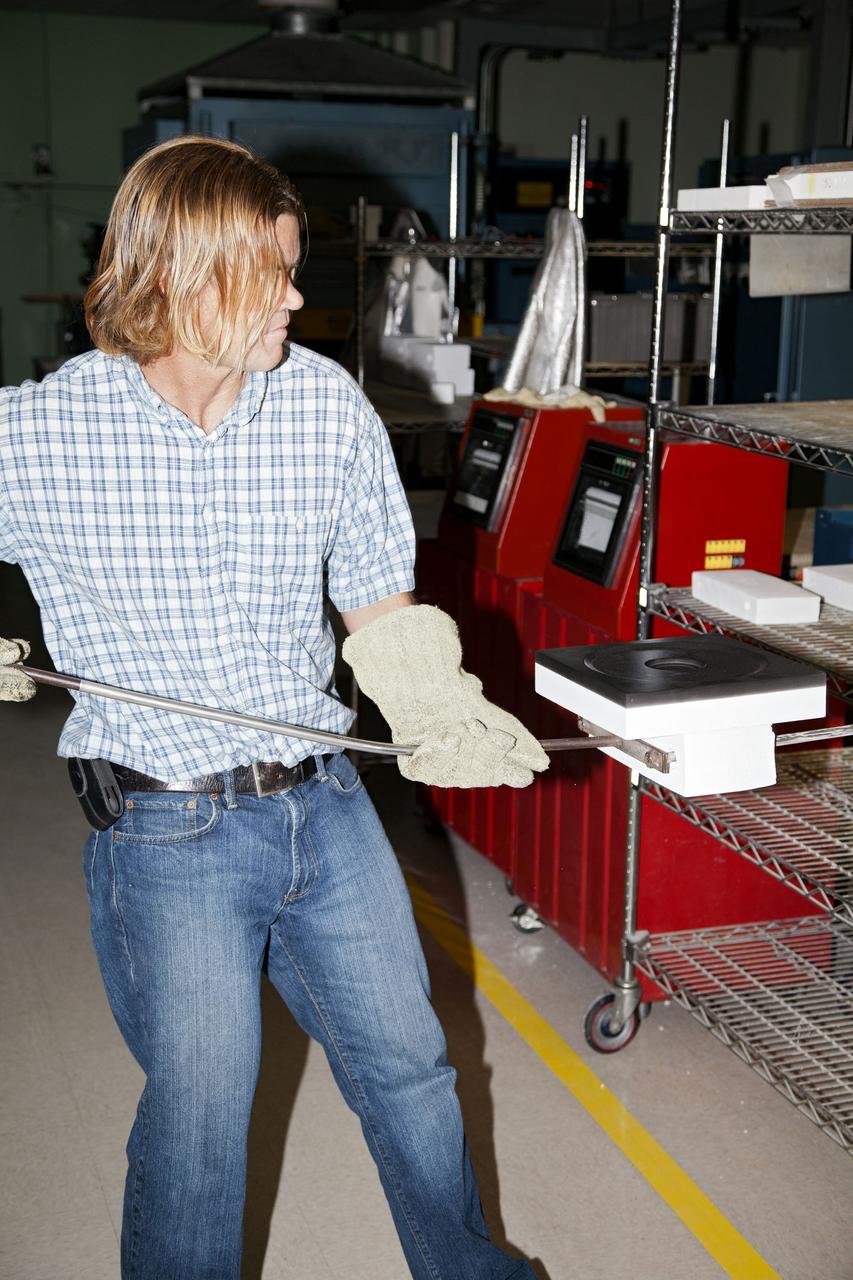 CAPE CANAVERAL, Fla. -- Tim Wright, a United Space Alliance engineering manager at NASA's Kennedy Space Center in Florida, removes the heat shield tiles that will be installed to the backshell of the Orion Multi-Purpose Crew Vehicle's Exploration Flight Test EFT-1 capsule from a Keith thermal automation oven. Inside, the tiles were baked at 2,200 degrees F to cure their ceramic coating. The work to manufacture and inspect the tiles is taking place in Kennedy's Thermal Protection System Facility. EFT-1 will be used during Orion's first test flight in space. For more information, visit www.nasa.gov/orion. Photo credit: Frankie Martin