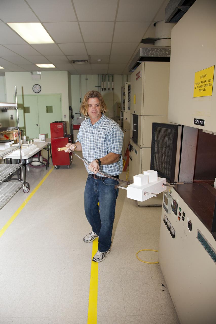 CAPE CANAVERAL, Fla. -- Tim Wright, a United Space Alliance engineering manager at NASA's Kennedy Space Center in Florida, removes the heat shield tiles that will be installed to the backshell of the Orion Multi-Purpose Crew Vehicle's Exploration Flight Test EFT-1 capsule from a Keith thermal automation oven. Inside, the tiles were baked at 2,200 degrees F to cure their ceramic coating. The work to manufacture and inspect the tiles is taking place in Kennedy's Thermal Protection System Facility. EFT-1 will be used during Orion's first test flight in space. For more information, visit www.nasa.gov/orion. Photo credit: Frankie Martin