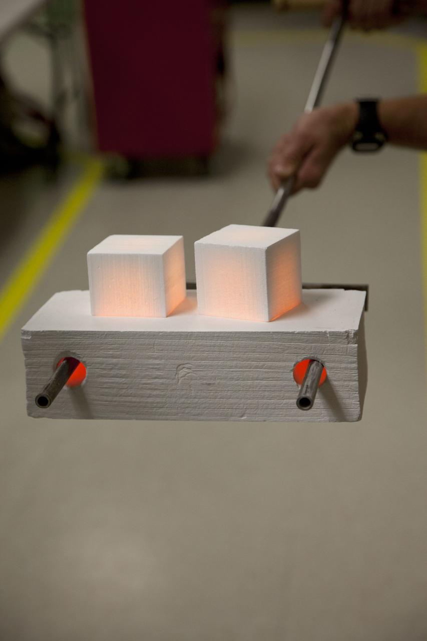 CAPE CANAVERAL, Fla. -- The heat shield tiles that will be installed to the backshell of the Orion Multi-Purpose Crew Vehicle's Exploration Flight Test EFT-1 capsule are removed from a Keith thermal automation oven. Inside, the tiles were baked at 2,200 degrees F to cure their ceramic coating. The work to manufacture and inspect the tiles is taking place in Kennedy's Thermal Protection System Facility. EFT-1 will be used during Orion's first test flight in space. For more information, visit www.nasa.gov/orion. Photo credit: Frankie Martin