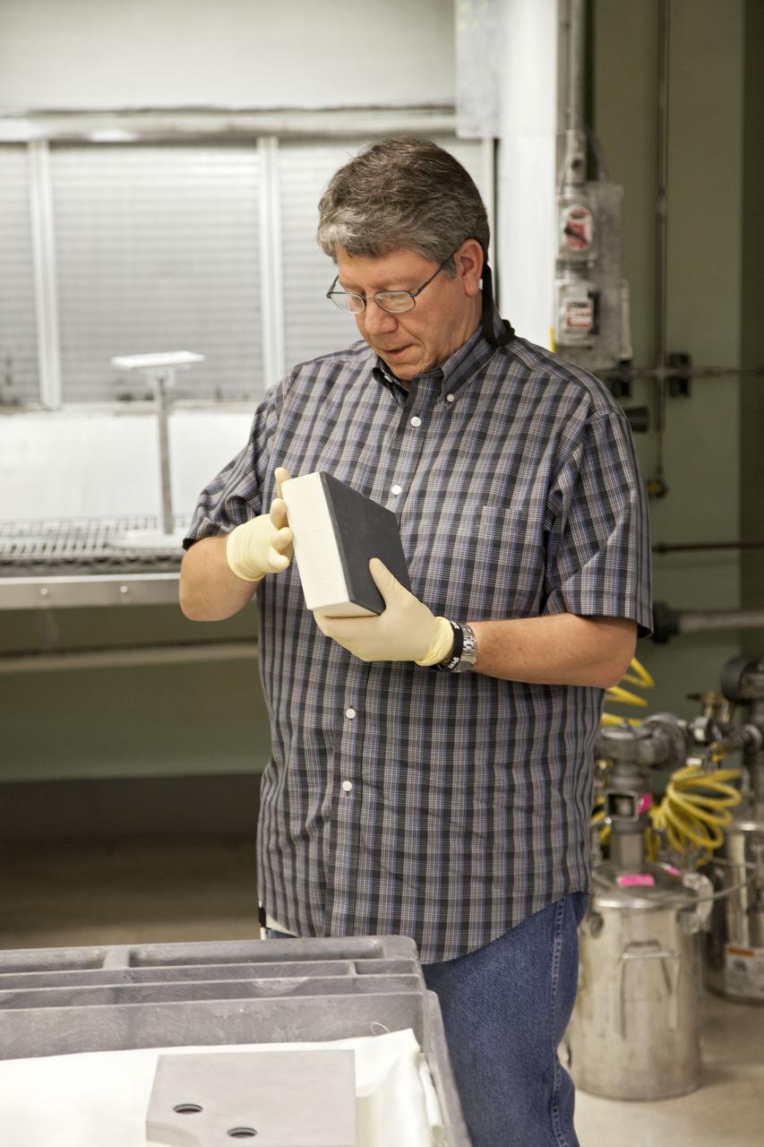 CAPE CANAVERAL, Fla. -- Frank Pelkey, a United Space Alliance technician at NASA's Kennedy Space Center in Florida, inspects a heat shield tile that will be installed to the backshell of the Orion Multi-Purpose Crew Vehicle's Exploration Flight Test EFT-1 capsule. The work to manufacture and inspect the tiles is taking place in Kennedy's Thermal Protection System Facility. EFT-1 will be used during Orion's first test flight in space. For more information, visit www.nasa.gov/orion. Photo credit: Frankie Martin