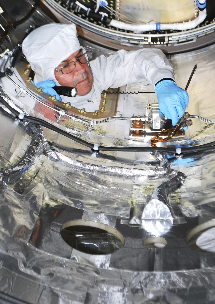 VANDENBERG AIR FORCE BASE, Calif. -- An Orbital Sciences technician is performing closeout work inside the fairing that will be installed around NASA's Nuclear Spectroscopic Telescope Array NuSTAR spacecraft in processing facility 1555 at Vandenberg Air Force Base in California. The fairing will protect the spacecraft from the heat and aerodynamic pressure generated during ascent to orbit aboard an Orbital Sciences Pegasus XL rocket. After processing of the rocket and spacecraft are complete, they will be flown on Orbital's L-1011 carrier aircraft from Vandenberg to the Ronald Reagan Ballistic Missile Defense Test Site on the Pacific Ocean’s Kwajalein Atoll for launch. The high-energy X-ray telescope will conduct a census of black holes, map radioactive material in young supernovae remnants, and study the origins of cosmic rays and the extreme physics around collapsed stars. For more information, visit http://www.nasa.gov/nustar. Photo credit: NASA/Randy Beaudoin, VAFB