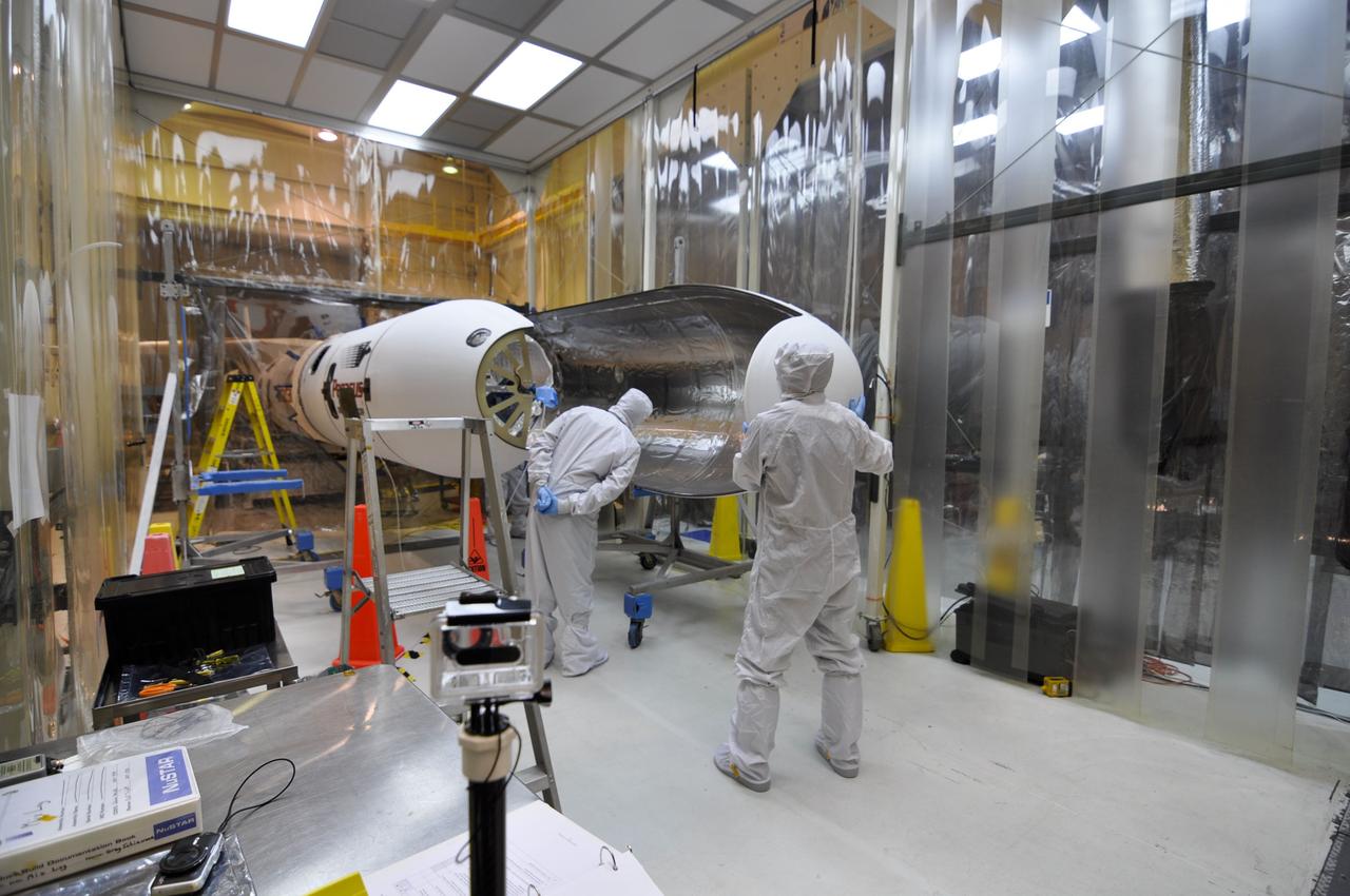 VANDENBERG AIR FORCE BASE, Calif. – Orbital Sciences technicians move the second section of the Pegasus payload fairing toward NASA's Nuclear Spectroscopic Telescope Array, or NuSTAR, inside the Orbital Sciences processing facility at Vandenberg Air Force Base in California. NuSTAR already is mated to its Pegasus XL rocket, which is positioned outside the environmental enclosure, at left. Encapsulation of NuSTAR in its fairing is a significant prelaunch milestone. The fairing will protect the spacecraft from the heat and aerodynamic pressure generated during ascent to orbit. After processing of the rocket and spacecraft are complete, they will be flown on Orbital's L-1011 carrier aircraft from Vandenberg to the Ronald Reagan Ballistic Missile Defense Test Site on the Pacific Ocean’s Kwajalein Atoll for launch in March. The high-energy x-ray telescope will conduct a census of black holes, map radioactive material in young supernovae remnants, and study the origins of cosmic rays and the extreme physics around collapsed stars. For more information, visit http://www.nasa.gov/nustar. Photo credit: NASA/Randy Beaudoin, VAFB