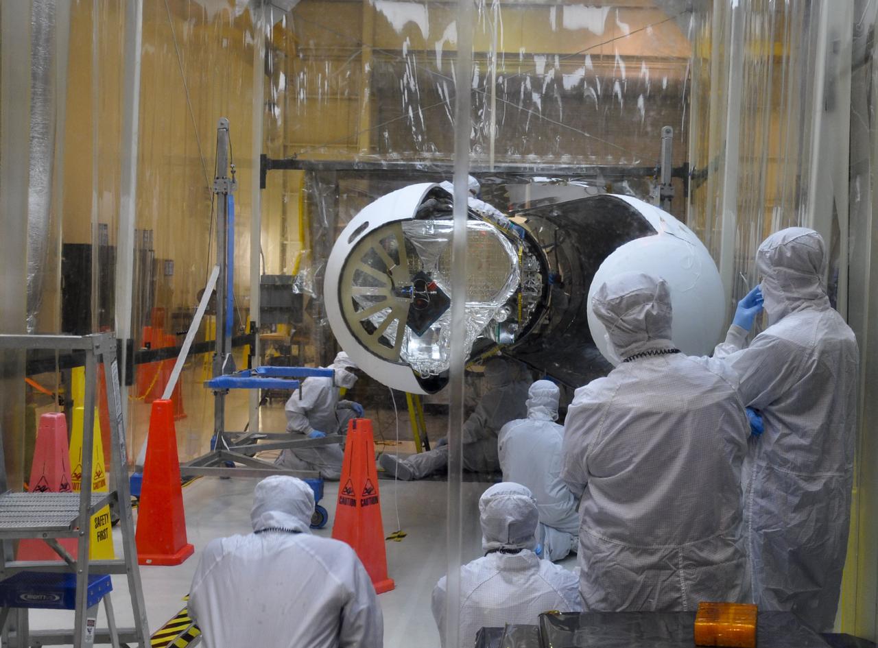 VANDENBERG AIR FORCE BASE, Calif. – Orbital Sciences technicians closely monitor the second section of the Pegasus payload fairing from every angle before it is secured around NASA's Nuclear Spectroscopic Telescope Array, or NuSTAR, inside the Orbital Sciences processing facility at Vandenberg Air Force Base in California. NuSTAR already is mated to its Pegasus XL rocket, which is positioned behind the spacecraft outside the environmental enclosure. Encapsulation of NuSTAR in its fairing is a significant prelaunch milestone. The fairing will protect the spacecraft from the heat and aerodynamic pressure generated during ascent to orbit. After processing of the rocket and spacecraft are complete, they will be flown on Orbital's L-1011 carrier aircraft from Vandenberg to the Ronald Reagan Ballistic Missile Defense Test Site on the Pacific Ocean’s Kwajalein Atoll for launch in March. The high-energy x-ray telescope will conduct a census of black holes, map radioactive material in young supernovae remnants, and study the origins of cosmic rays and the extreme physics around collapsed stars. For more information, visit http://www.nasa.gov/nustar. Photo credit: NASA/Randy Beaudoin, VAFB