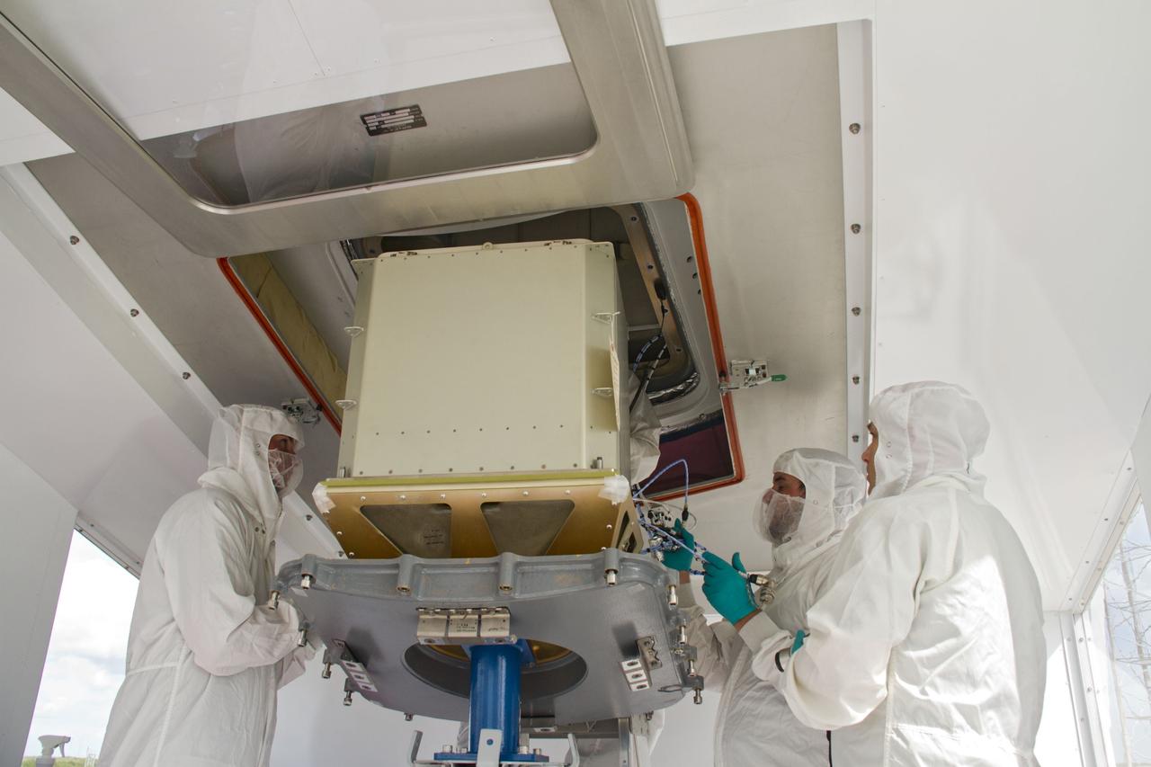 CAPE CANAVERAL, Fla. – In a processing facility at Space Launch Complex-40 on Cape Canaveral Air Force Station in Florida, a cargo container is lifted toward the open hatch of a Dragon capsule.  The Dragon is set to launch aboard a Falcon 9 rocket.    The new rocket and capsule were designed and manufactured by Space Exploration Technologies Corp., or SpaceX, for the company’s upcoming demonstration test flight for NASA’s Commercial Orbital Transportation Services, or COTS, program.  Under COTS, NASA has partnered with two private companies to develop the capability to deliver cargo to the International Space Station.  During the flight, SpaceX's Dragon capsule will conduct a series of checkout procedures that will test and prove its systems. These tests include rendezvous and berthing with the space station and are intended to lead to regular resupply missions to the station.  Liftoff is targeted for April 30 at 12:22 p.m. EDT pending official approval at the Flight Readiness Review on April 16.  For more information, visit www.nasa.gov/exploration/commercial/cargo/spacex_index.html.  Photo credit: NASA/Cory Huston