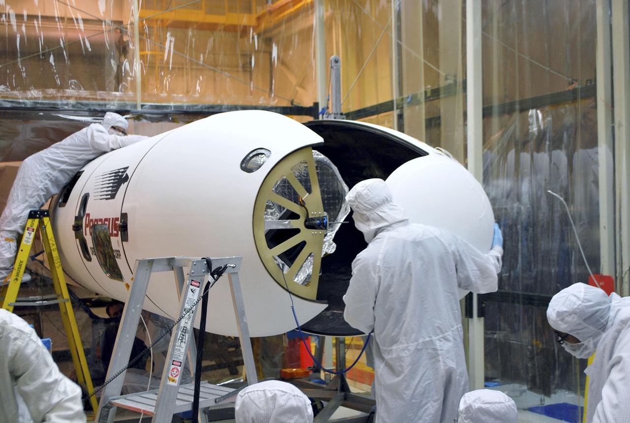 VANDENBERG AIR FORCE BASE, Calif. – Inside the Orbital Sciences processing facility at Vandenberg Air Force Base in California, the installation of the Pegasus payload fairing around NASA's Nuclear Spectroscopic Telescope Array, or NuSTAR, is in progress. On Feb. 17, NuSTAR was mated to its Pegasus XL rocket, which is positioned behind the spacecraft outside the environmental enclosure. The fairing will protect the spacecraft from the heat and aerodynamic pressure generated during ascent to orbit. Encapsulation of NuSTAR in its fairing is a significant prelaunch milestone. After processing of the rocket and spacecraft are complete, they will be flown on Orbital's L-1011 carrier aircraft from Vandenberg to the Ronald Reagan Ballistic Missile Defense Test Site on the Pacific Ocean’s Kwajalein Atoll for launch in March. The high-energy x-ray telescope will conduct a census of black holes, map radioactive material in young supernovae remnants, and study the origins of cosmic rays and the extreme physics around collapsed stars. For more information, visit http://www.nasa.gov/nustar. Photo credit: NASA/Randy Beaudoin, VAFB