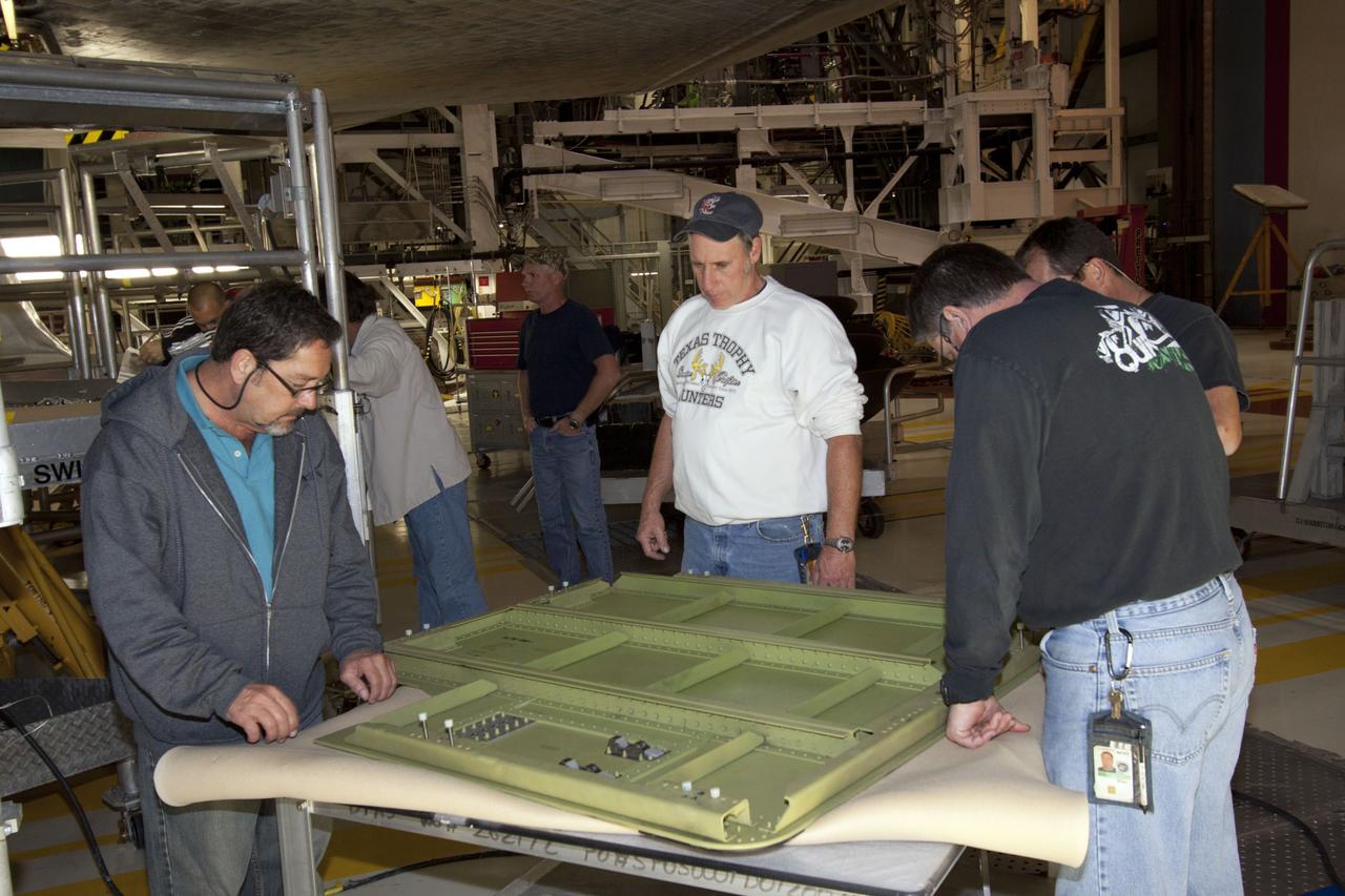 CAPE CANAVERAL, Fla. – Inside Orbiter Processing Facility-1 at NASA’s Kennedy Space Center in Florida, technicians review procedures before installing the ferry flight doors on space shuttle Discovery. The work is part of the Space Shuttle Program’s transition and retirement processing of shuttle Discovery, which is being prepared for display at Smithsonian’s National Air and Space Museum, Steven F. Udvar-Hazy Center in Chantilly, Va. Discovery is scheduled to be transported atop a NASA Shuttle Carrier Aircraft modified 747 jet to Dulles International Airport in Virginia on April 17 and then moved to the Smithsonian for permanent public display on April 19. For more information, visit http://www.nasa.gov/shuttle. Photo credit: NASA/Jim Grossmann