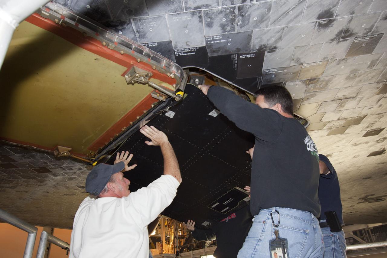 CAPE CANAVERAL, Fla. – Inside Orbiter Processing Facility-1 at NASA’s Kennedy Space Center in Florida, technicians position a ferry flight door for installation on space shuttle Discovery.     The work is part of the Space Shuttle Program’s transition and retirement processing of shuttle Discovery, which is being prepared for display at Smithsonian’s National Air and Space Museum, Steven F. Udvar-Hazy Center in Chantilly, Va. Discovery is scheduled to be transported atop a NASA Shuttle Carrier Aircraft modified 747 jet to Dulles International Airport in Virginia on April 17 and then moved to the Smithsonian for permanent public display on April 19. For more information, visit http://www.nasa.gov/shuttle.  Photo credit: NASA/Jim Grossmann