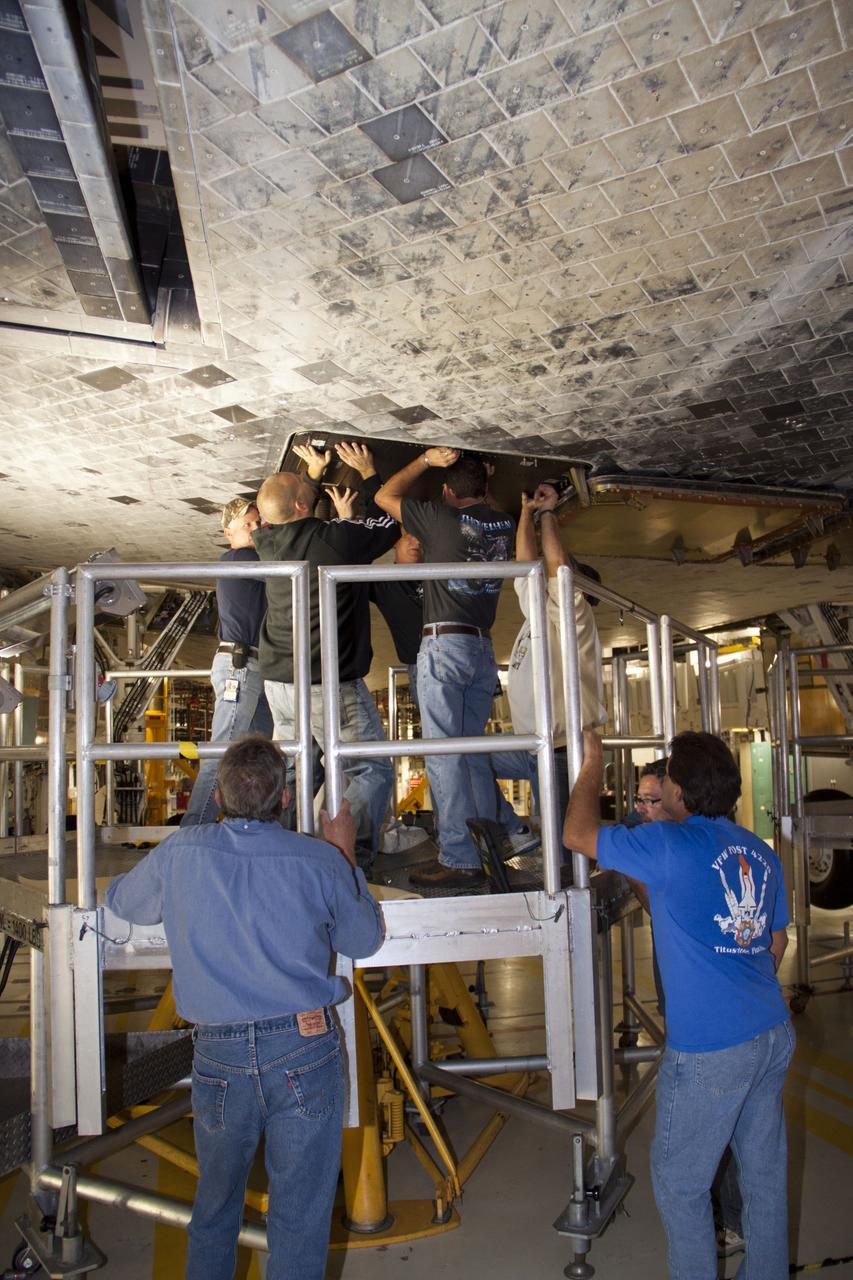 CAPE CANAVERAL, Fla. – Inside Orbiter Processing Facility-1 at NASA’s Kennedy Space Center in Florida, technicians install a ferry flight door on space shuttle Discovery.    The work is part of the Space Shuttle Program’s transition and retirement processing of shuttle Discovery, which is being prepared for display at Smithsonian’s National Air and Space Museum, Steven F. Udvar-Hazy Center in Chantilly, Va. Discovery is scheduled to be transported atop a NASA Shuttle Carrier Aircraft modified 747 jet to Dulles International Airport in Virginia on April 17 and then moved to the Smithsonian for permanent public display on April 19. For more information, visit http://www.nasa.gov/shuttle.  Photo credit: NASA/Jim Grossmann