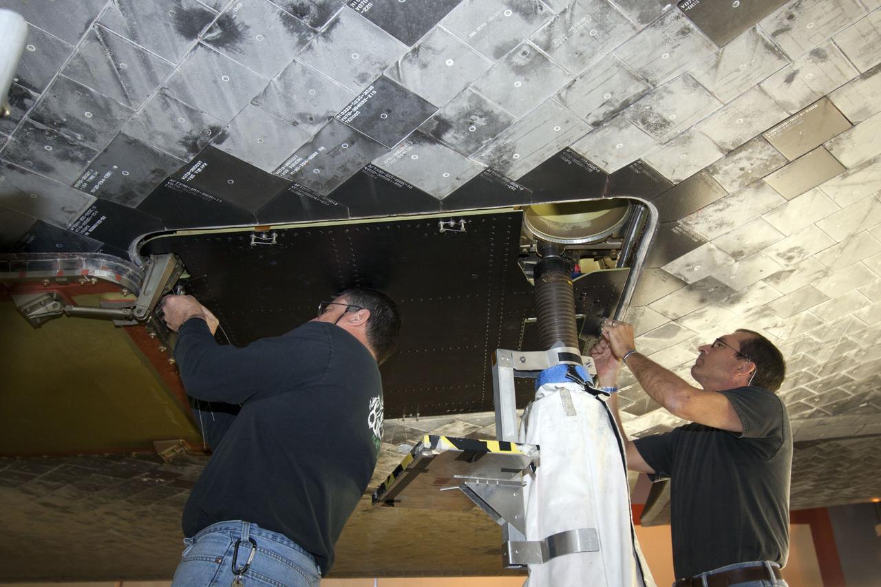 CAPE CANAVERAL, Fla. – Inside Orbiter Processing Facility-1 at NASA’s Kennedy Space Center in Florida, technicians install a ferry flight door on space shuttle Discovery.    The work is part of the Space Shuttle Program’s transition and retirement processing of shuttle Discovery, which is being prepared for display at Smithsonian’s National Air and Space Museum, Steven F. Udvar-Hazy Center in Chantilly, Va. Discovery is scheduled to be transported atop a NASA Shuttle Carrier Aircraft modified 747 jet to Dulles International Airport in Virginia on April 17 and then moved to the Smithsonian for permanent public display on April 19. For more information, visit http://www.nasa.gov/shuttle.  Photo credit: NASA/Jim Grossmann