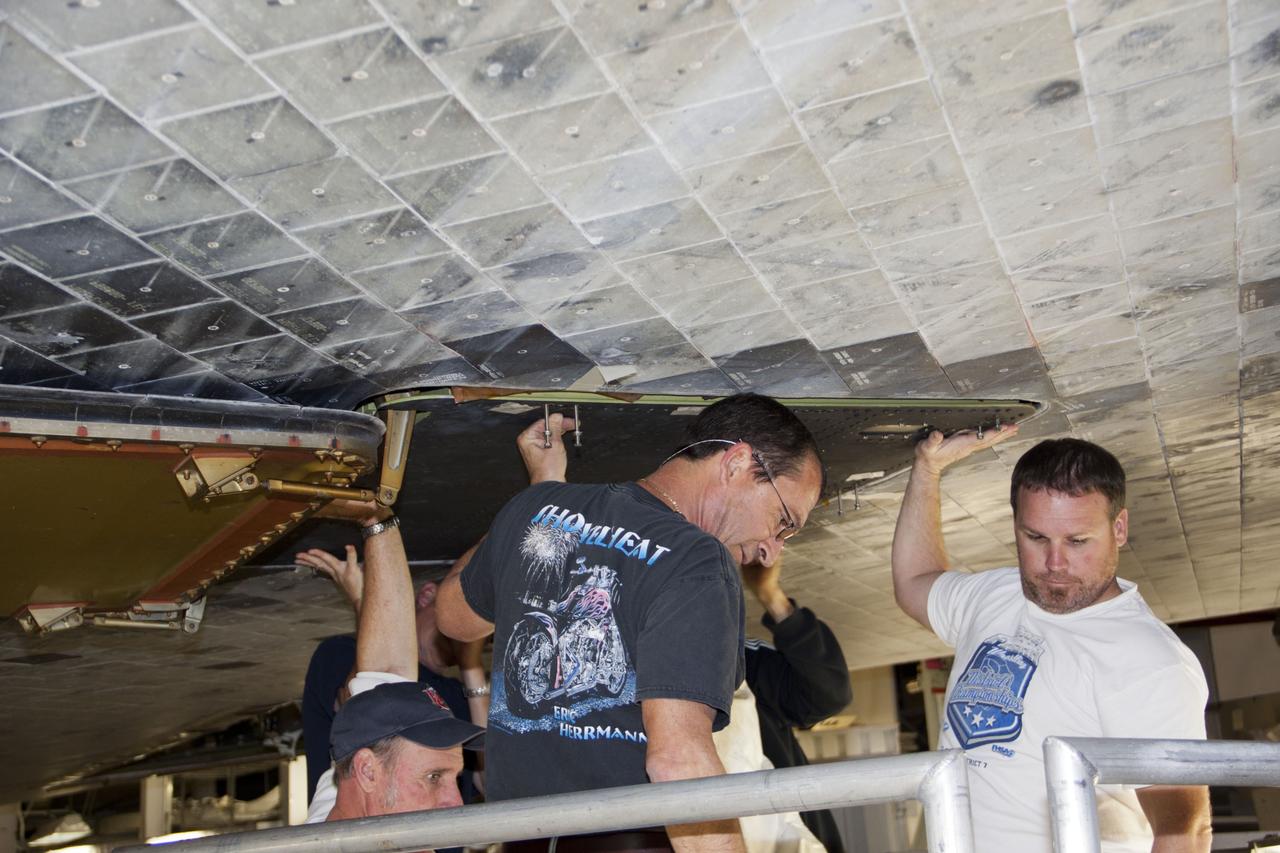 CAPE CANAVERAL, Fla. – Inside Orbiter Processing Facility-1 at NASA’s Kennedy Space Center in Florida, technicians install a ferry flight door on space shuttle Discovery.    The work is part of the Space Shuttle Program’s transition and retirement processing of shuttle Discovery, which is being prepared for display at Smithsonian’s National Air and Space Museum, Steven F. Udvar-Hazy Center in Chantilly, Va. Discovery is scheduled to be transported atop a NASA Shuttle Carrier Aircraft modified 747 jet to Dulles International Airport in Virginia on April 17 and then moved to the Smithsonian for permanent public display on April 19. For more information, visit http://www.nasa.gov/shuttle.  Photo credit: NASA/Jim Grossmann