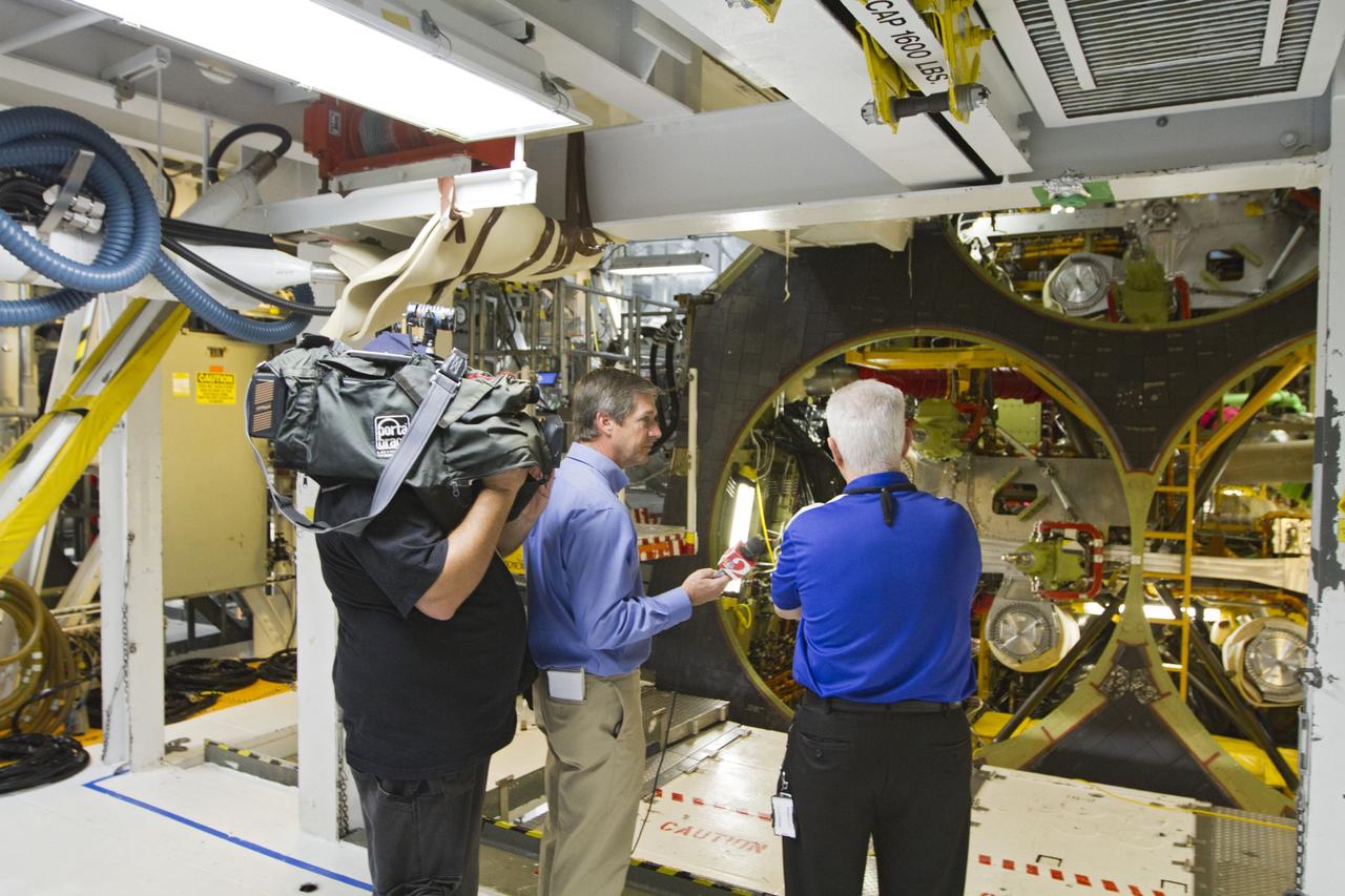 CAPE CANAVERAL, Fla. -- Members of the news media interview Walter "Buddy" McKenzie, right, manager of technical operations with United Space Alliance, in front of space shuttle Endeavour's aft engine compartment inside Orbiter Processing Facility-2 at NASA's Kennedy Space Center in Florida. McKenzie was one of several shuttle experts available for interviews around the outside of Endeavour and inside the shuttle's crew compartment.    Ongoing transition and retirement activities are preparing the spacecraft for public display at the California Science Center in Los Angeles. Endeavour flew 25 missions during its 19-year career. Photo credit: NASA/Kim Shiflett