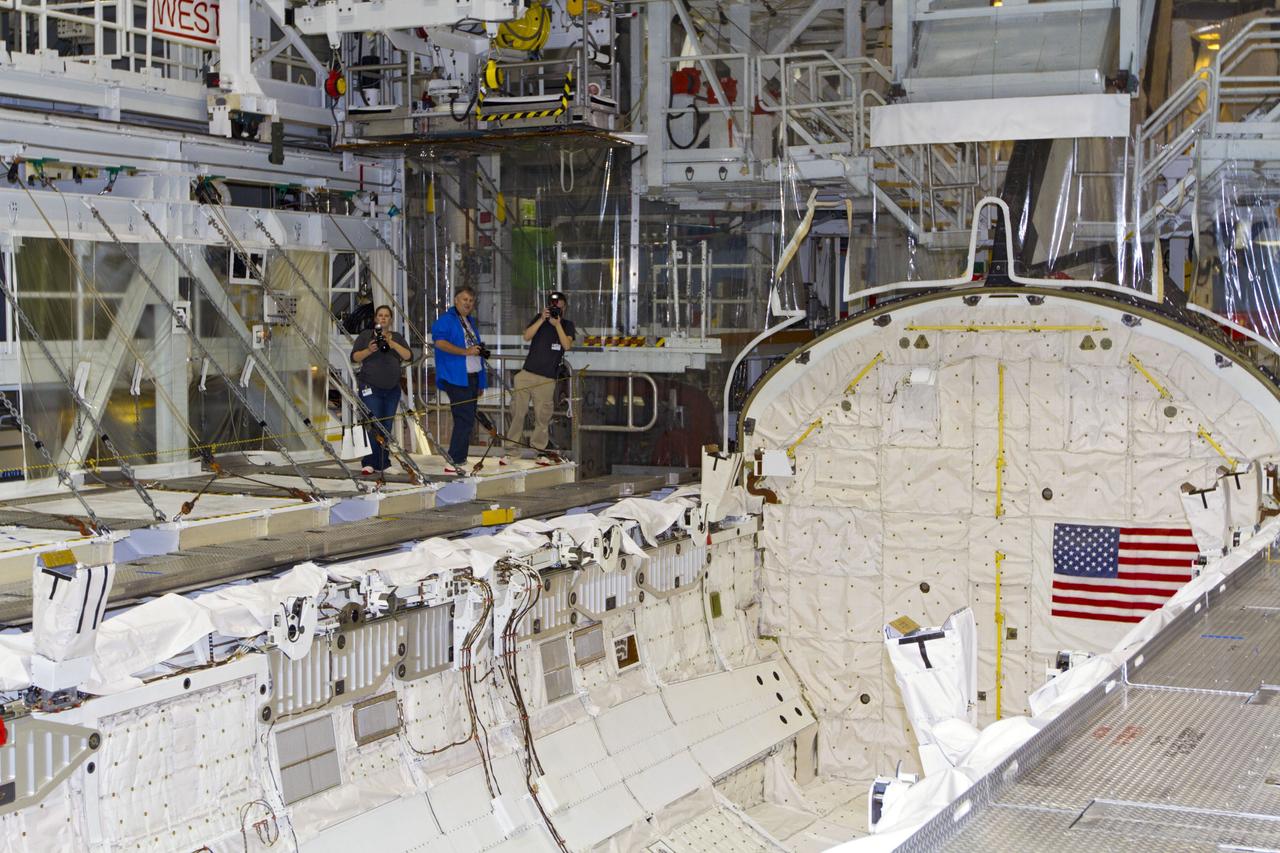 CAPE CANAVERAL, Fla. -- Positioned on a platform inside Orbiter Processing Facility-2 at NASA's Kennedy Space Center in Florida, members of the news media photograph space shuttle Endeavour's open payload bay.     Ongoing transition and retirement activities are preparing the spacecraft for public display at the California Science Center in Los Angeles. Endeavour flew 25 missions during its 19-year career. Photo credit: NASA/Kim Shiflett