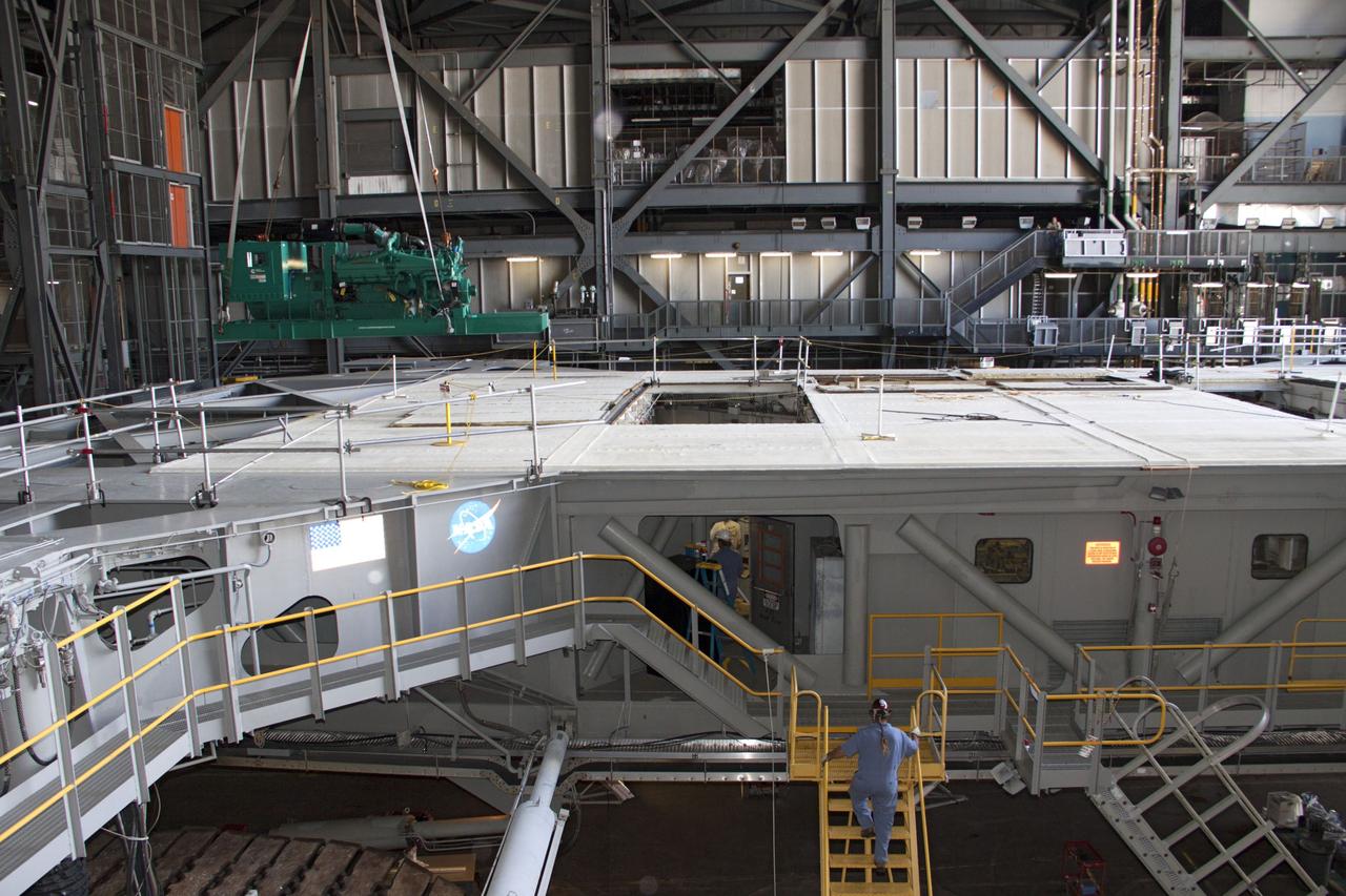 CAPE CANAVERAL, Fla. – Inside the Vehicle Assembly Building at NASA’s Kennedy Space Center in Florida, a large crane lifts a new engine and generator high overhead for installation on crawler-transporter 2 CT-2). The Apollo era diesel engines were removed last month.     Work continues in high bay 2 to upgrade CT-2 so that it can carry NASA’s Space Launch System heavy-lift rocket, which is under design, and new Orion spacecraft to the launch pad. The crawler-transporters were used to carry the mobile launcher platform and space shuttle to Launch Complex 39 for space shuttle launches for 30 years.  Photo credit: NASA/Jim Grossmann