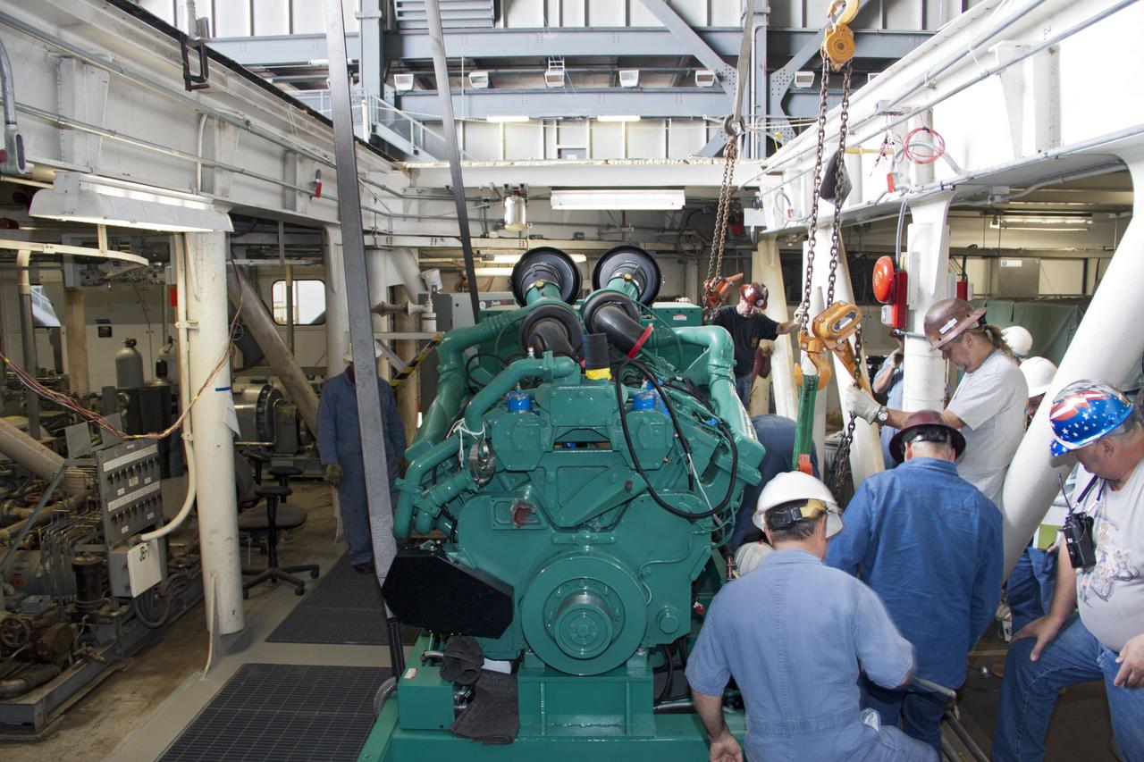 CAPE CANAVERAL, Fla. – Inside the Vehicle Assembly Building at NASA’s Kennedy Space Center in Florida, technicians begin the work to secure a new engine and generator inside crawler-transporter 2 CT-2). The Apollo era diesel engines were removed last month. Work continues in high bay 2 to upgrade CT-2 so that it can carry NASA’s Space Launch System heavy-lift rocket, which is under design, and new Orion spacecraft to the launch pad. The crawler-transporters were used to carry the mobile launcher platform and space shuttle to Launch Complex 39 for space shuttle launches for 30 years. Photo credit: NASA/Jim Grossmann