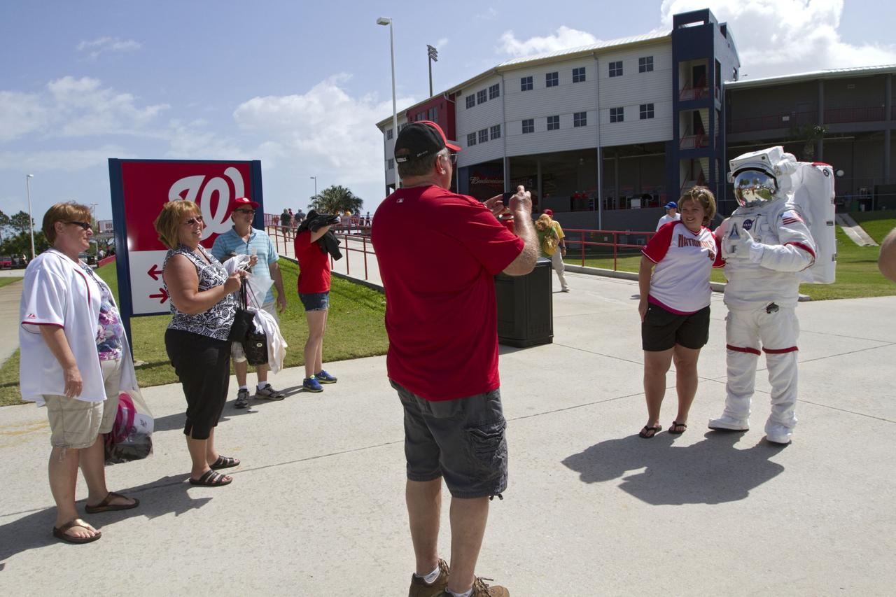 VIERA, Fla. – Baseball fans take the opportunity to pose with NASA Kennedy Space Center’s “Spaceperson” on Space Day at the Space Coast Stadium. Bob Cabana, director of Kennedy, was on hand to throw the first pitch of a spring training game between Major League Baseball's Washington Nationals and the Houston Astros. Kennedy also set up a booth at the stadium for the occasion to highlight some of the contributions the space agency has made to sports, transportation and everyday life. A full-scale test version of NASA's new Orion Multi-Purpose Crew Vehicle was on display outside the stadium to show the public the spacecraft under development that will take astronauts farther into space than ever before. For more information, visit http://www.nasa.gov/kennedy. Photo credit: NASA/Kim Shiflett