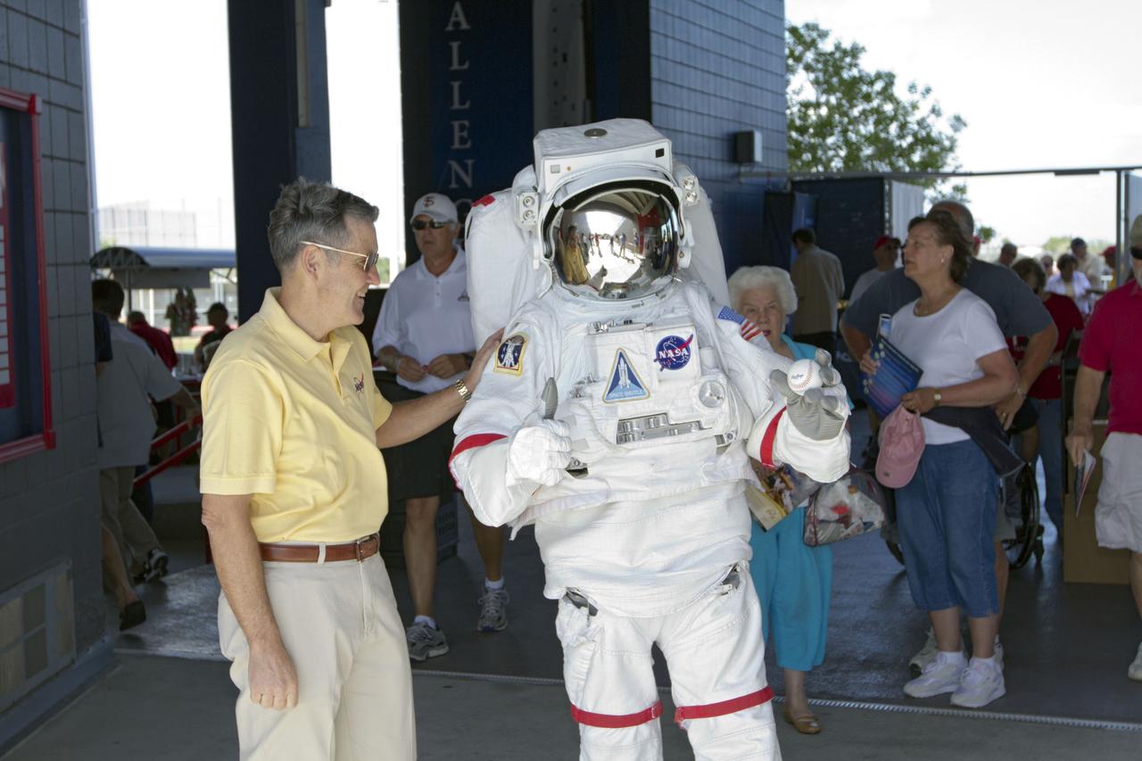 VIERA, Fla. – Bob Cabana, left, director of NASA’s Kennedy Space Center in Florida, allows Kennedy’s “Spaceperson” to hold the ball he will use to make the first pitch of a spring training game between Major League Baseball's Washington Nationals and the Houston Astros at the Space Coast Stadium’s Space Day. Kennedy set up a booth at the stadium for the occasion to highlight some of the contributions the space agency has made to sports, transportation and everyday life. A full-scale test version of NASA's new Orion Multi-Purpose Crew Vehicle also was located outside the stadium to show the public the spacecraft under development that will take astronauts farther into space than ever before. For more information, visit http://www.nasa.gov/kennedy. Photo credit: NASA/Kim Shiflett