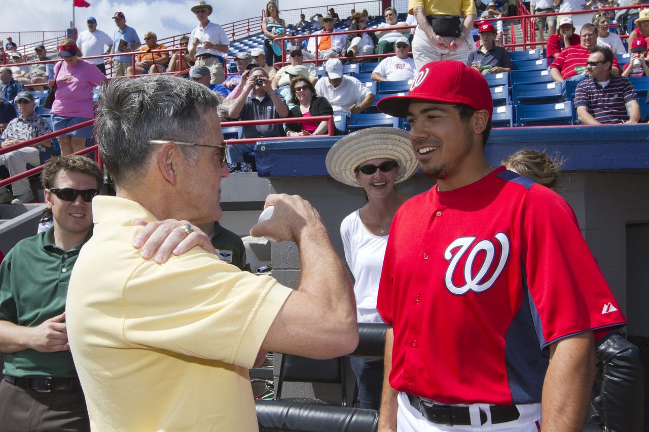 VIERA, Fla. – NASA Kennedy Space Center Director Bob Cabana, left, consults with third baseman Anthony Rendon of Major League Baseball’s Washington Nationals prior to Cabana’s throwing the first pitch of a spring training game between the Nationals and the Houston Astros at the Space Coast Stadium’s Space Day. Kennedy set up a booth at the stadium for the occasion to highlight some of the contributions the space agency has made to sports, transportation and everyday life. A full-scale test version of NASA's new Orion Multi-Purpose Crew Vehicle also was on display outside the stadium to show the public the spacecraft under development that will take astronauts farther into space than ever before. For more information, visit http://www.nasa.gov/kennedy. Photo credit: NASA/Kim Shiflett