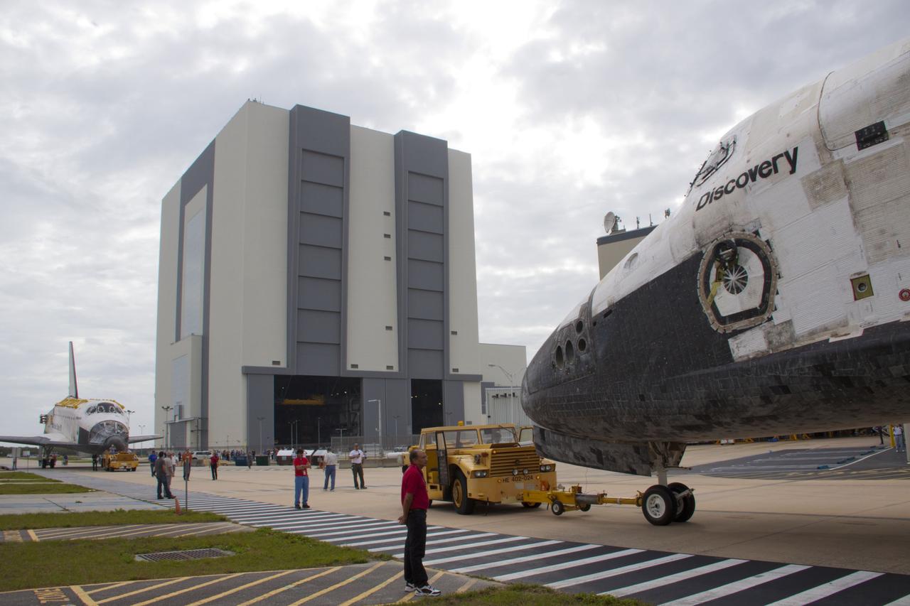 CAPE CANAVERAL, Fla. – At NASA’s Kennedy Space Center in Florida, space shuttle Discovery in the foreground is on the move from Orbiter Processing Facility-1 OPF-1 to the Vehicle Assembly Building VAB. Meanwhile, space shuttle Atlantis is being towed from the VAB to OPF-1.     The work is part of the Space Shuttle Program’s transition and retirement processing of shuttle Discovery, which is being prepared for display at Smithsonian’s National Air and Space Museum, Steven F. Udvar-Hazy Center in Chantilly, Va. Discovery will remain in high bay 4 of the VAB until its scheduled transport atop a NASA Shuttle Carrier Aircraft modified 747 jet to Dulles International Airport in Virginia on April 17. Discovery will then be transported to the Smithsonian on April 19. For more information, visit http://www.nasa.gov/shuttle.  Photo credit: NASA/Jim Grossmann
