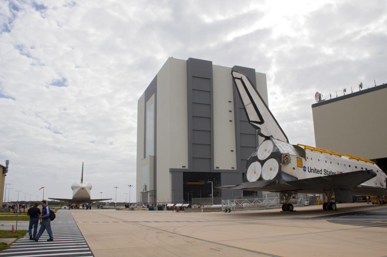 CAPE CANAVERAL, Fla. – At NASA’s Kennedy Space Center in Florida, space shuttle Atlantis foreground is towed in to Orbiter Processing Facility-1 after being towed from the Vehicle Assembly Building VAB. Workers will continue to prepare Atlantis for display at the Kennedy Space Center Visitor Complex. Meanwhile, space shuttle Discovery is on the move from OPF-1 to the Vehicle Assembly Building VAB. The aft view of Discovery reveals the tail cone that covers the three replica shuttle main engines. The work is part of the Space Shuttle Program’s transition and retirement processing of shuttle Discovery, which is being prepared for display at Smithsonian’s National Air and Space Museum, Steven F. Udvar-Hazy Center in Chantilly, Va. Discovery will remain in high bay 4 of the VAB until its scheduled transport atop a NASA Shuttle Carrier Aircraft modified 747 jet to Dulles International Airport in Virginia on April 17. Discovery will then be transported to the Smithsonian on April 19. For more information, visit http://www.nasa.gov/shuttle. Photo credit: NASA/Jim Grossmann