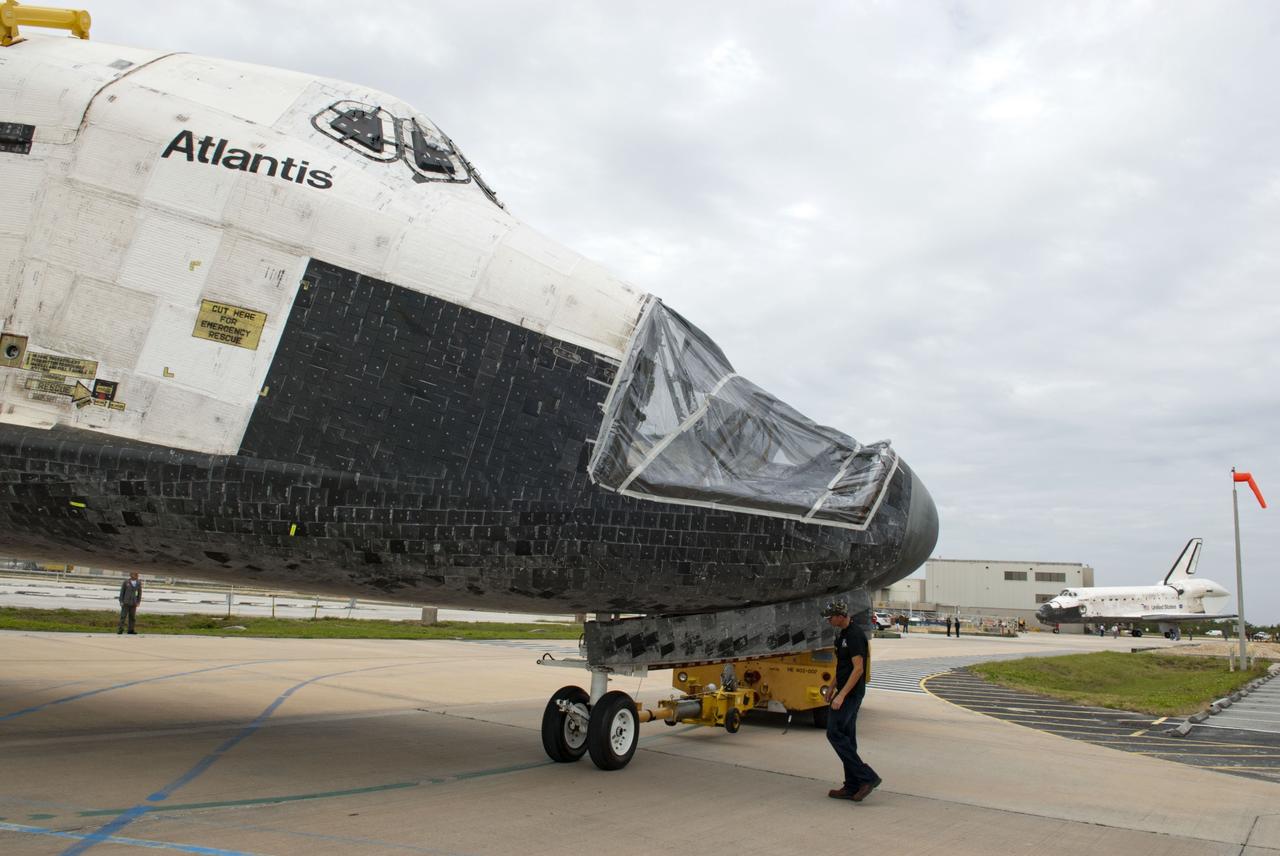 CAPE CANAVERAL, Fla. – At NASA’s Kennedy Space Center in Florida, a technician monitors space shuttle Atlantis as it is towed from the Vehicle Assembly Building toward Orbiter Processing Facility-1. A view of Atlantis’ nose cone area shows that the forward reaction control system has been removed. The work is part of the Space Shuttle Program’s transition and retirement processing of the three space shuttles. Atlantis is being prepared for display at the Kennedy Space Center Visitor Complex and is scheduled to rollover to the complex in November. Photo credit: NASA/Tim Jacobs