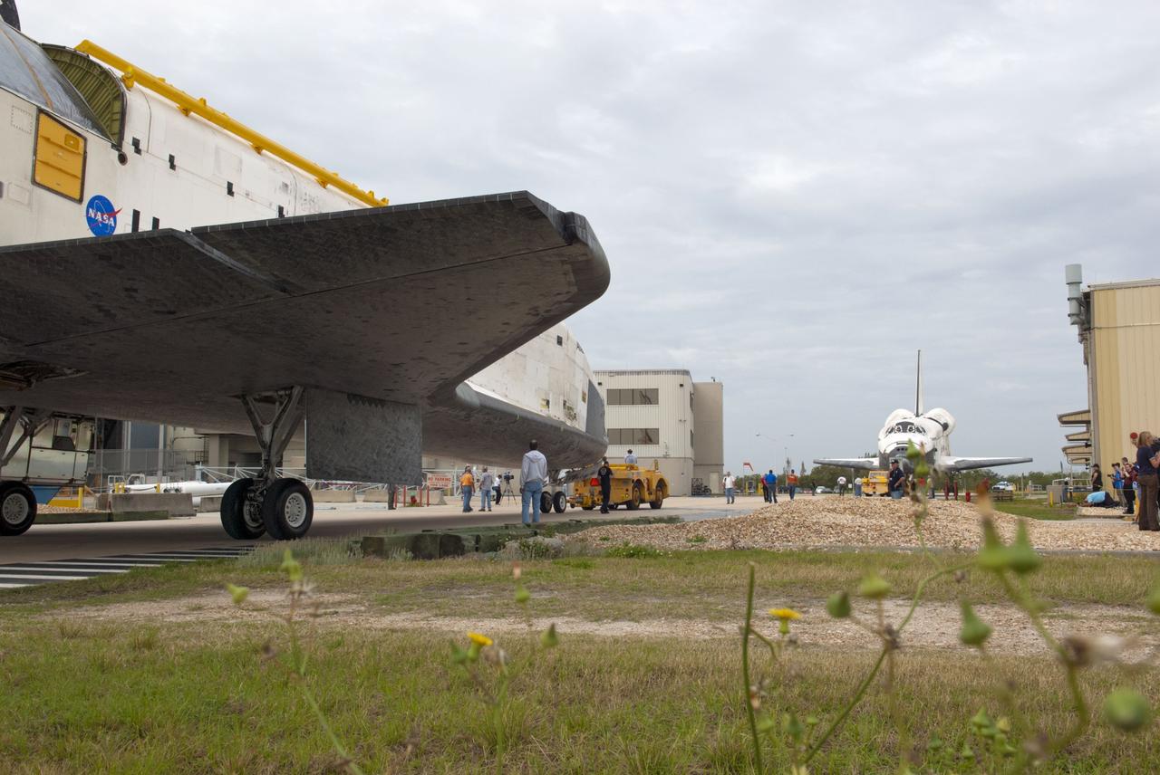 CAPE CANAVERAL, Fla. – At NASA’s Kennedy Space Center in Florida, space shuttle Atlantis is towed from the Vehicle Assembly Building toward Orbiter Processing Facility-1 OPF-1. In the background, space shuttle Discovery faces Atlantis after it was completely towed out from OPF-1. The work is part of the Space Shuttle Program’s transition and retirement processing of the three space shuttles. Atlantis is being prepared for display at the Kennedy Space Center Visitor Complex and is scheduled to rollover to the complex in November. Photo credit: NASA/Tim Jacobs