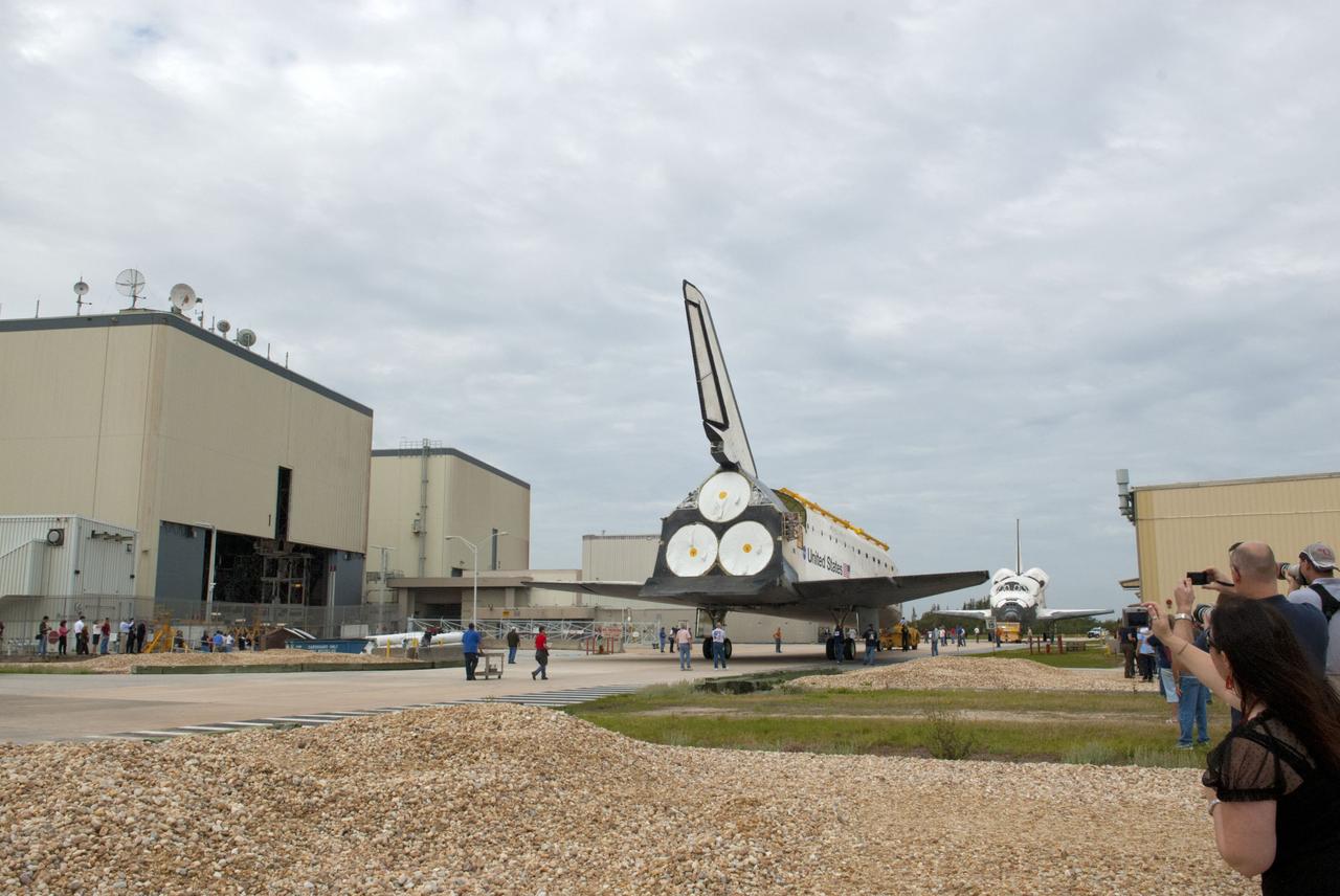 CAPE CANAVERAL, Fla. – At NASA’s Kennedy Space Center in Florida, space shuttle Atlantis is towed from the Vehicle Assembly Building toward Orbiter Processing Facility-1 OPF-1. In the background, space shuttle Discovery faces Atlantis after it was completely towed out from OPF-1. The work is part of the Space Shuttle Program’s transition and retirement processing of the three space shuttles. Atlantis is being prepared for display at the Kennedy Space Center Visitor Complex and is scheduled to rollover to the complex in November. Photo credit: NASA/Tim Jacobs
