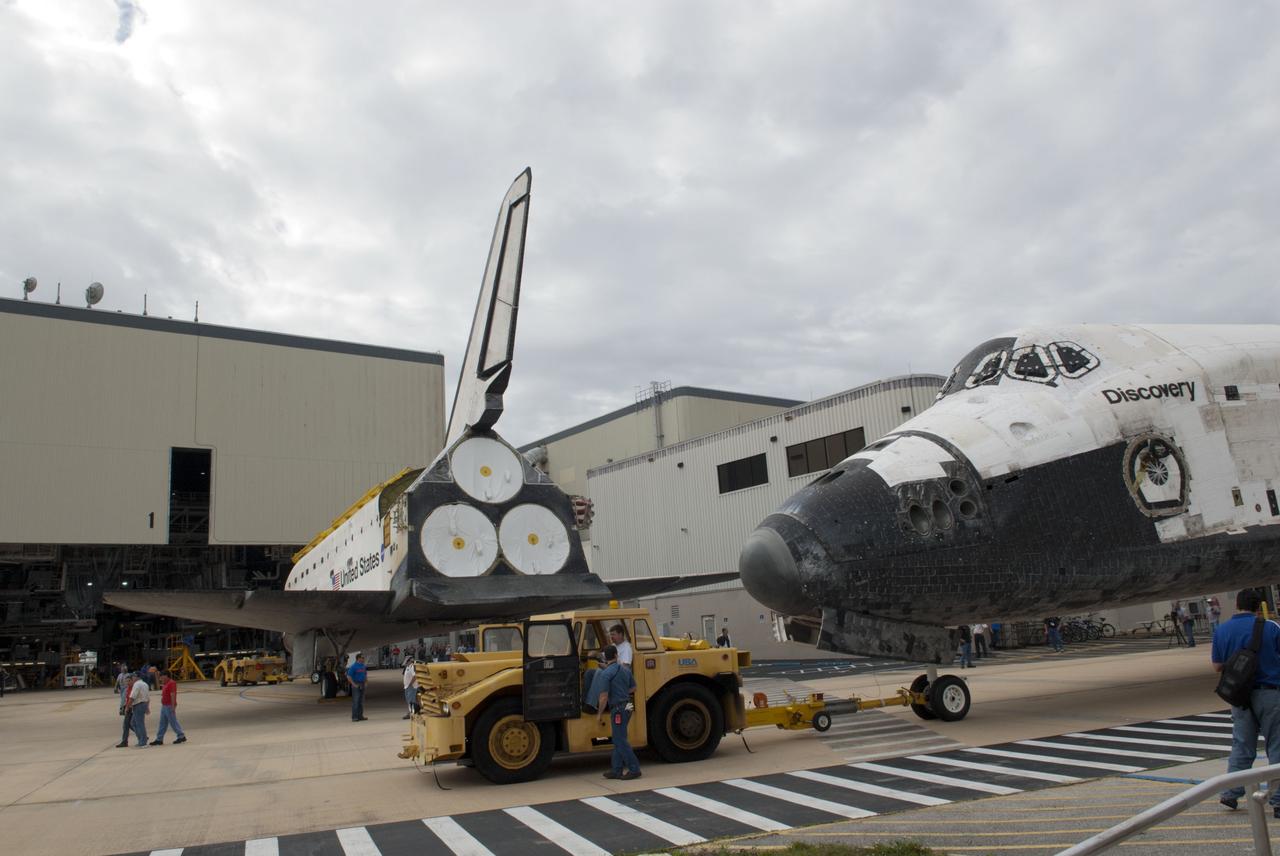 CAPE CANAVERAL, Fla. – At NASA’s Kennedy Space Center in Florida, space shuttle Atlantis is towed toward Orbiter Processing Facility-1 OPF-1 after being towed from the Vehicle Assembly Building VAB. In the foreground, space shuttle Discovery is being towed to the VAB after being towed out of OPF-1. The work is part of the Space Shuttle Program’s transition and retirement processing of the three space shuttles. Atlantis is being prepared for display at the Kennedy Space Center Visitor Complex and is scheduled to rollover to the complex in November. Photo credit: NASA/Tim Jacobs