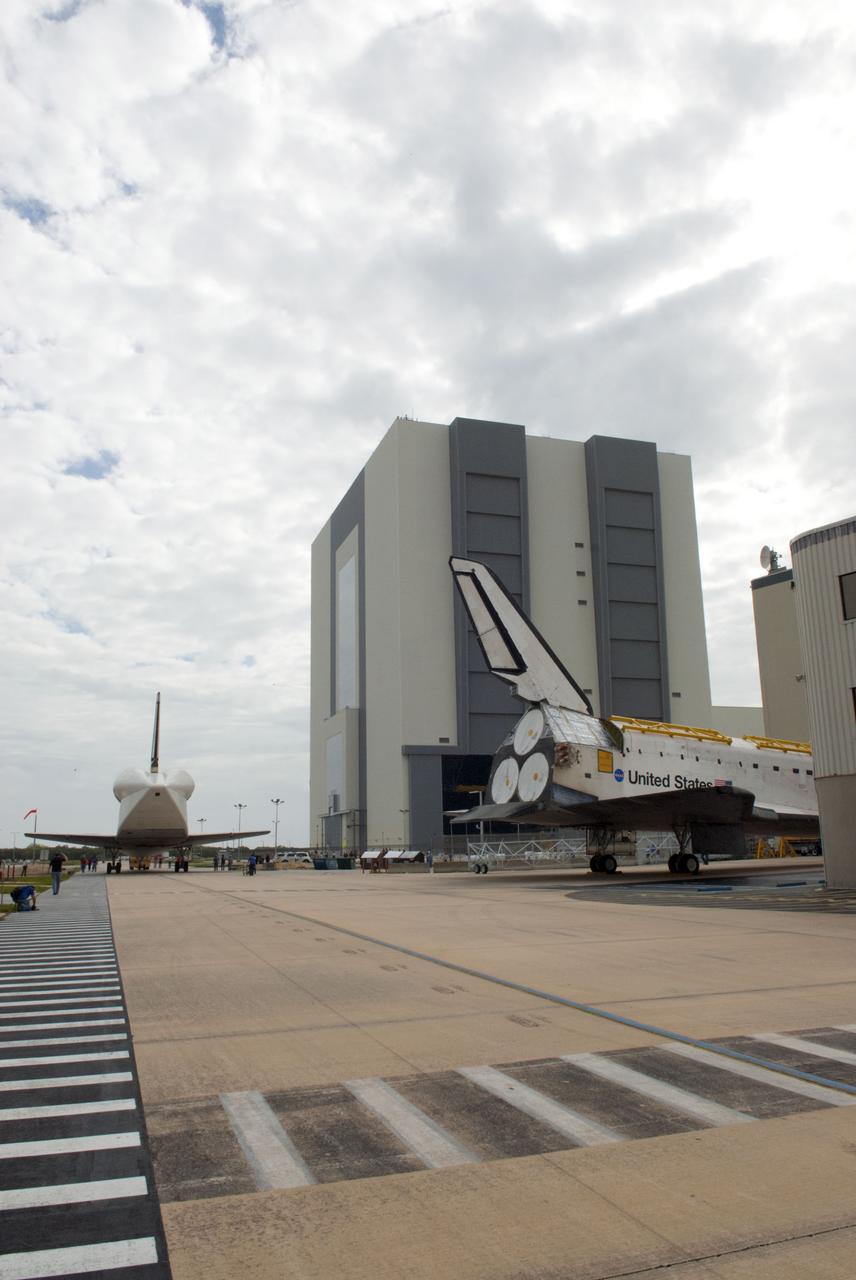 CAPE CANAVERAL, Fla. – At NASA’s Kennedy Space Center in Florida, space shuttle Atlantis is towed toward Orbiter Processing Facility-1 OPF-1 after being towed from the Vehicle Assembly Building VAB. At left, space shuttle Discovery is being towed to the VAB after being towed out of OPF-1. The tail cone protects Discovery’s three replica shuttle main engines. The work is part of the Space Shuttle Program’s transition and retirement processing of the three space shuttles. Atlantis is being prepared for display at the Kennedy Space Center Visitor Complex and is scheduled to rollover to the complex in November. Photo credit: NASA/Tim Jacobs
