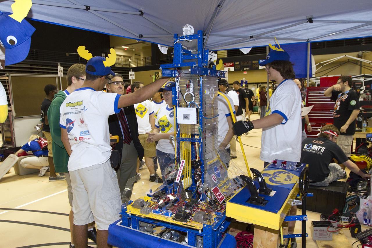ORLANDO, Fla. -- NASA Kennedy Space Center Director Bob Cabana talks with members of Team 1056 "The Moose," which is participating in the regional FIRST robotics competition at the University of Central Florida in Orlando, Fla. The team is from Kissimmee, Fla., and consists of students from Osceola High School. More than 60 high school teams from took part in the competition called "For Inspiration and Recognition of Science and Technology," or FIRST, in hopes of advancing to the national robotics championship. This year, the competition resembled a basketball game and was dubbed "Rebound Rumble." The game measured the effectiveness of each robot, the power of collaboration and the determination of the teams.    FIRST, founded in 1989, is a non-profit organization that designs accessible, innovative programs to build self-confidence, knowledge and life skills while motivating young people to pursue academic opportunities. The robotics competition challenges teams of high school students and their mentors to solve a common problem in a six-week timeframe using a standard kit of parts and a common set of rules. NASA is the largest sponsor of the international program. Kennedy Space Center is a sponsor of the regional event. For more information on Kennedy's education events and initiatives, go to http://www.nasa.gov/offices/education/centers/kennedy/home/index.html. Photo credit: NASA/Kim Shiflett