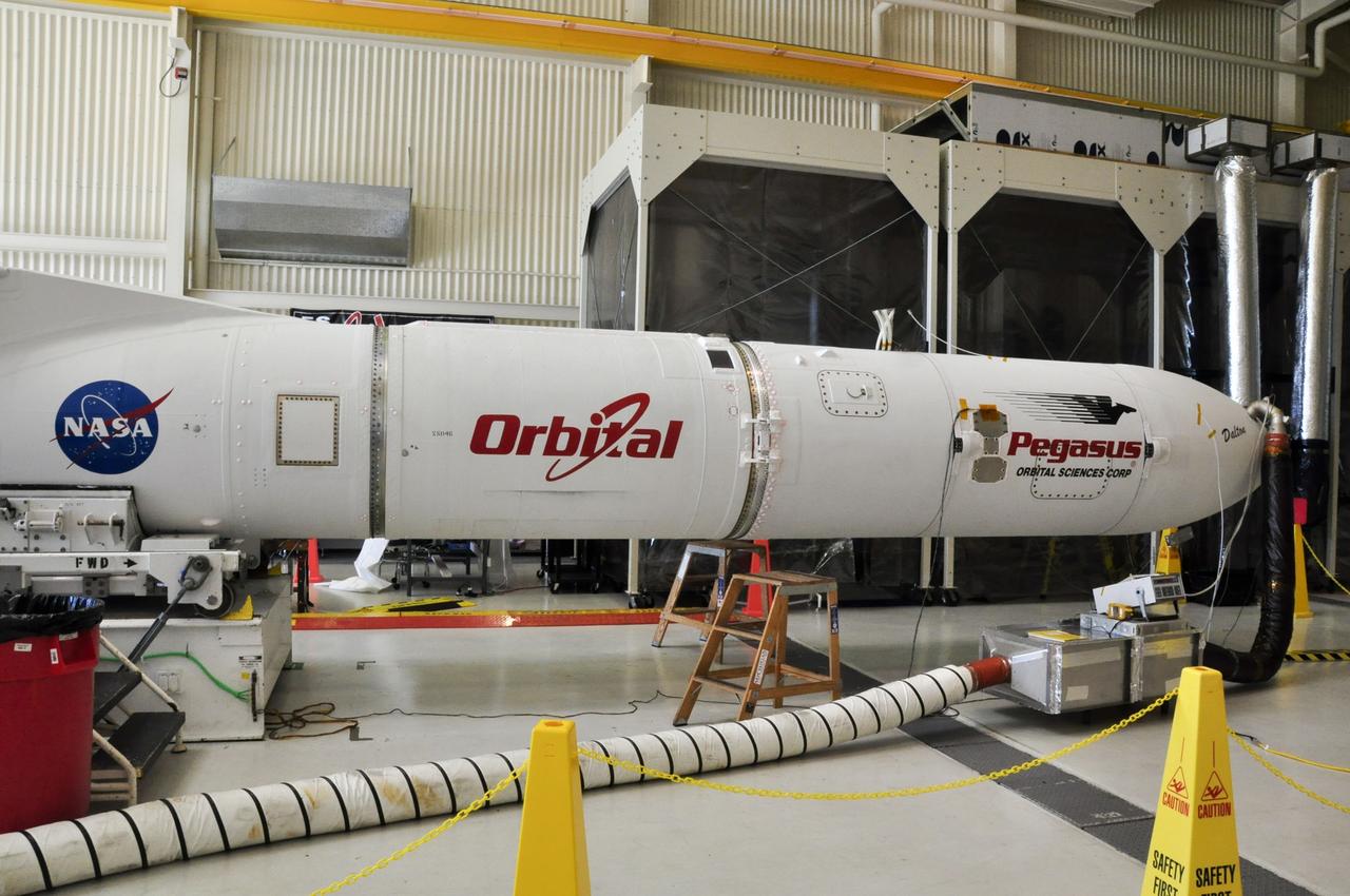 VANDENBERG AIR FORCE BASE, Calif. – Operations begin to transfer an Orbital Sciences Pegasus XL rocket onto the transporter in Orbital’s hangar at Vandenberg Air Force Base in California.  The rocket has been mated to NASA's Nuclear Spectroscopic Telescope Array, or NuSTAR, encapsulated in the Pegasus payload fairing.  Cool, dry air is being pumped into the fairing through a purge line to maintain the proper environment for the spacecraft in the confined space.    The transporter will move them to the runway ramp where they will be attached to the underside of Orbital’s L-1011 carrier aircraft. The aircraft will fly the pair from Vandenberg to the Ronald Reagan Ballistic Missile Defense Test Site on the Pacific Ocean’s Kwajalein Atoll for launch. A revised launch date will be set at the Flight Readiness Review, planned for later this week. The high-energy X-ray telescope will conduct a census of black holes, map radioactive material in young supernovae remnants, and study the origins of cosmic rays and the extreme physics around collapsed stars. For more information, visit http://www.nasa.gov/nustar.  Photo credit: NASA/Randy Beaudoin, VAFB