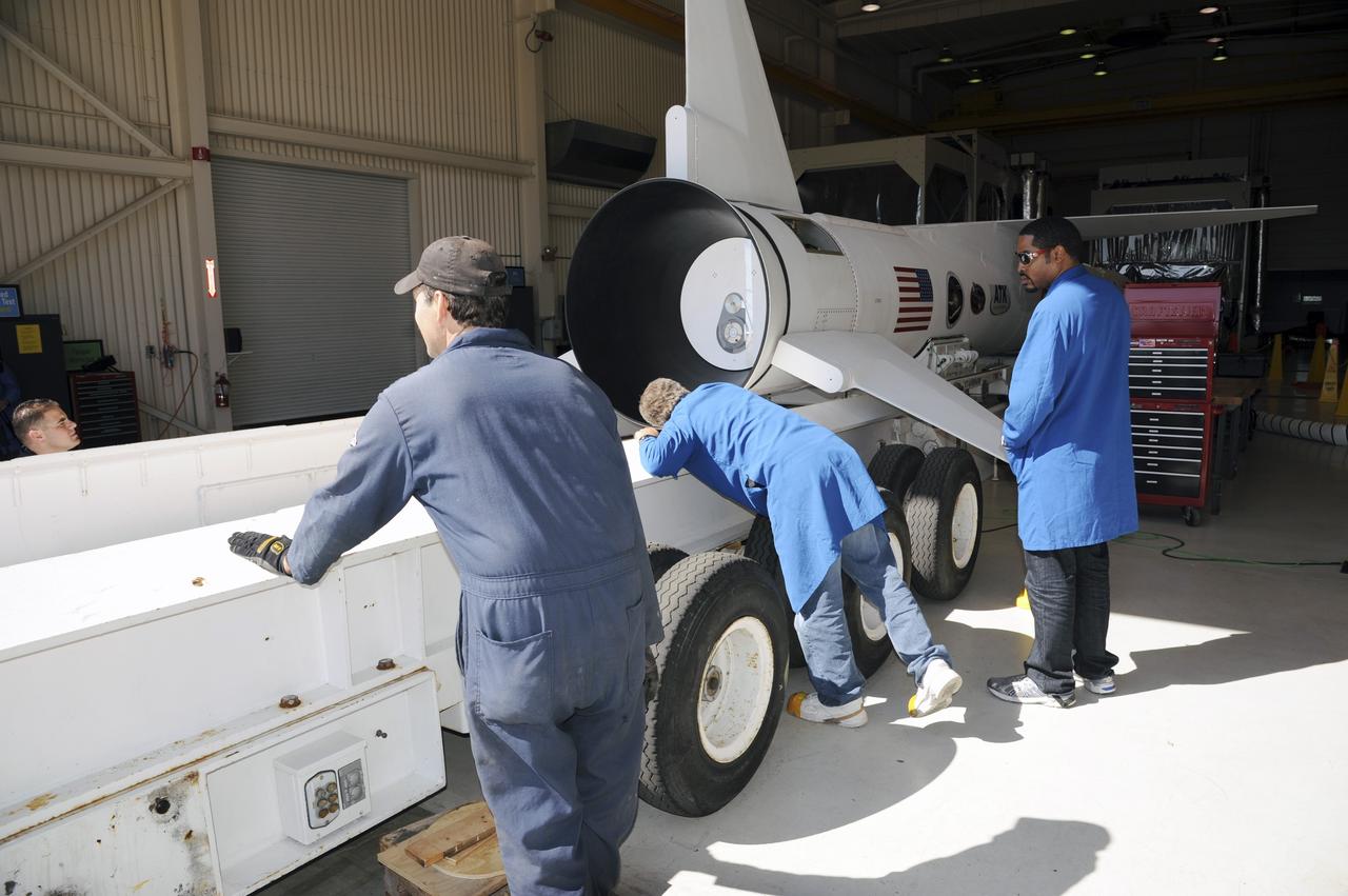 VANDENBERG AIR FORCE BASE, Calif. – At Vandenberg Air Force Base in California, technicians monitor the progress as a transporter is moved underneath the Orbital Science’s Pegasus XL inside Orbital’s hangar. The rocket is mated to NASA’s encapsulated Nuclear Spectroscopic Telescope Array, or NuSTAR, out of sight inside the hangar. The transporter will move them to the runway ramp where they will be attached to the underside of Orbital’s L-1011 carrier aircraft. The aircraft will fly the pair from Vandenberg to the Ronald Reagan Ballistic Missile Defense Test Site on the Pacific Ocean’s Kwajalein Atoll for launch. A revised launch date is expected to be set at the Flight Readiness Review. The high-energy X-ray telescope will conduct a census of black holes, map radioactive material in young supernovae remnants, and study the origins of cosmic rays and the extreme physics around collapsed stars. For more information, visit http://www.nasa.gov/nustar. Photo credit: NASA/Mark Mackiey