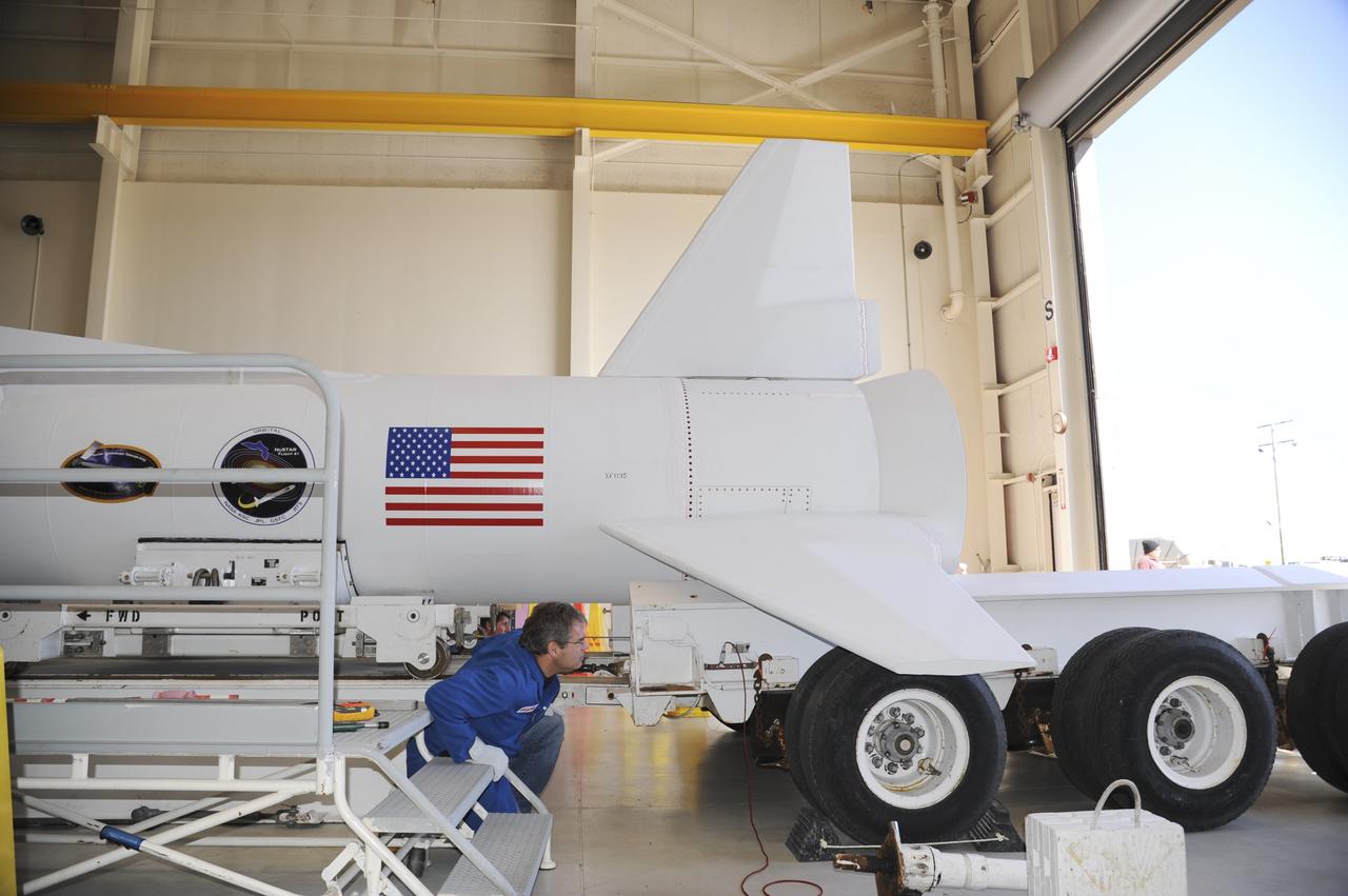 VANDENBERG AIR FORCE BASE, Calif. – At Vandenberg Air Force Base in California, a technician monitors the progress as a transporter is moved underneath the Orbital Science’s Pegasus XL inside Orbital’s hangar. The rocket is mated to NASA’s encapsulated Nuclear Spectroscopic Telescope Array, or NuSTAR, out of sight inside the hangar. The transporter will move them to the runway ramp where they will be attached to the underside of Orbital’s L-1011 carrier aircraft. The aircraft will fly the pair from Vandenberg to the Ronald Reagan Ballistic Missile Defense Test Site on the Pacific Ocean’s Kwajalein Atoll for launch. A revised launch date is expected to be set at the Flight Readiness Review. The high-energy X-ray telescope will conduct a census of black holes, map radioactive material in young supernovae remnants, and study the origins of cosmic rays and the extreme physics around collapsed stars. For more information, visit http://www.nasa.gov/nustar. Photo credit: NASA/Mark Mackiey