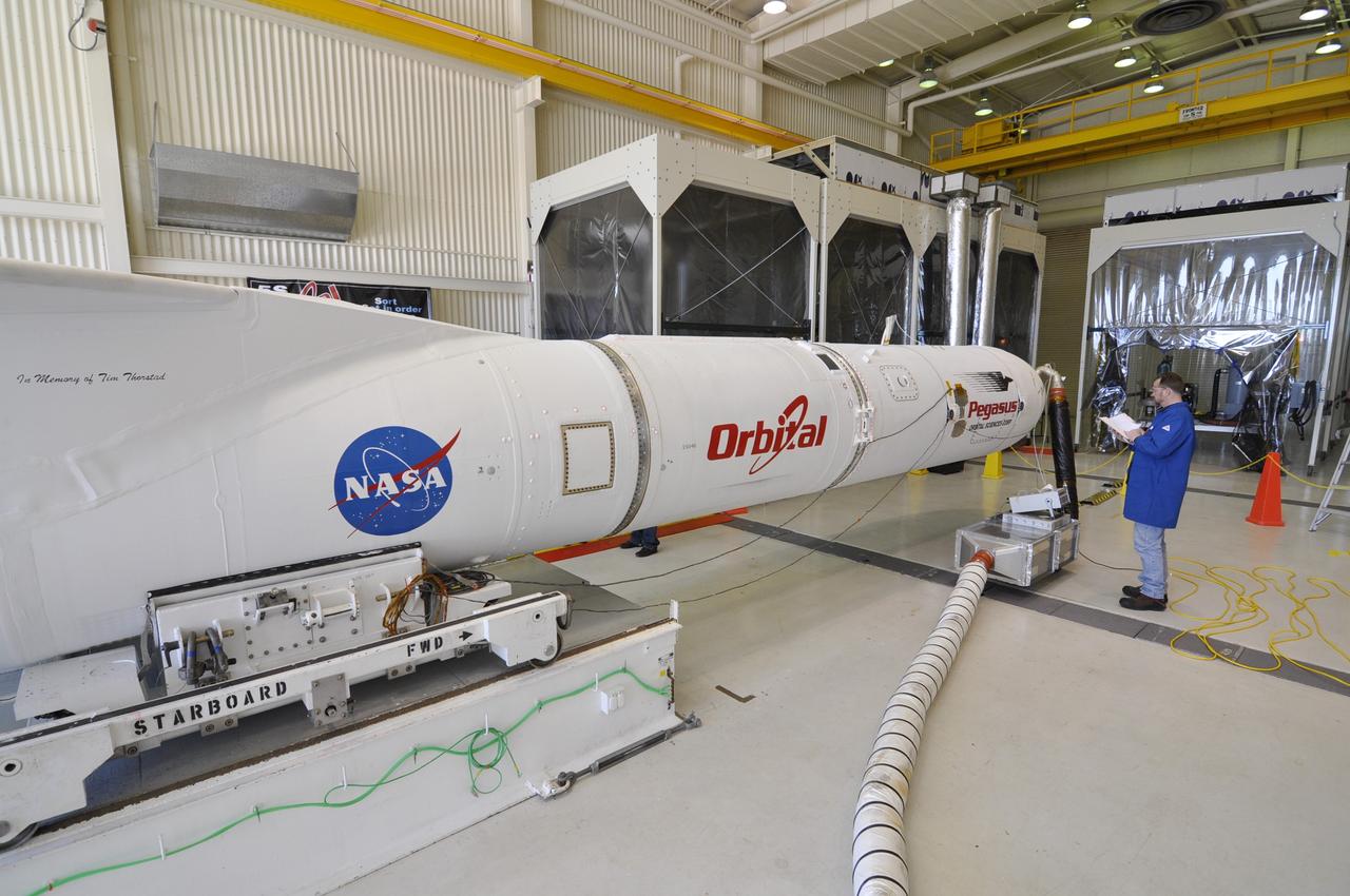 VANDENBERG AIR FORCE BASE, Calif. – At Vandenberg Air Force Base in California, a technician checks on the status of the Orbital Science’s Pegasus XL inside Orbital’s hangar. The rocket is mated to NASA’s encapsulated Nuclear Spectroscopic Telescope Array, or NuSTAR, spacecraft. A transporter will be used to move them to the runway ramp where they will be attached to the underside of Orbital’s L-1011 carrier aircraft. The aircraft will fly the pair from Vandenberg to the Ronald Reagan Ballistic Missile Defense Test Site on the Pacific Ocean’s Kwajalein Atoll for launch. A revised launch date is expected to be set at the Flight Readiness Review. The high-energy X-ray telescope will conduct a census of black holes, map radioactive material in young supernovae remnants, and study the origins of cosmic rays and the extreme physics around collapsed stars. For more information, visit http://www.nasa.gov/nustar. Photo credit: NASA/Randy Beaudoin