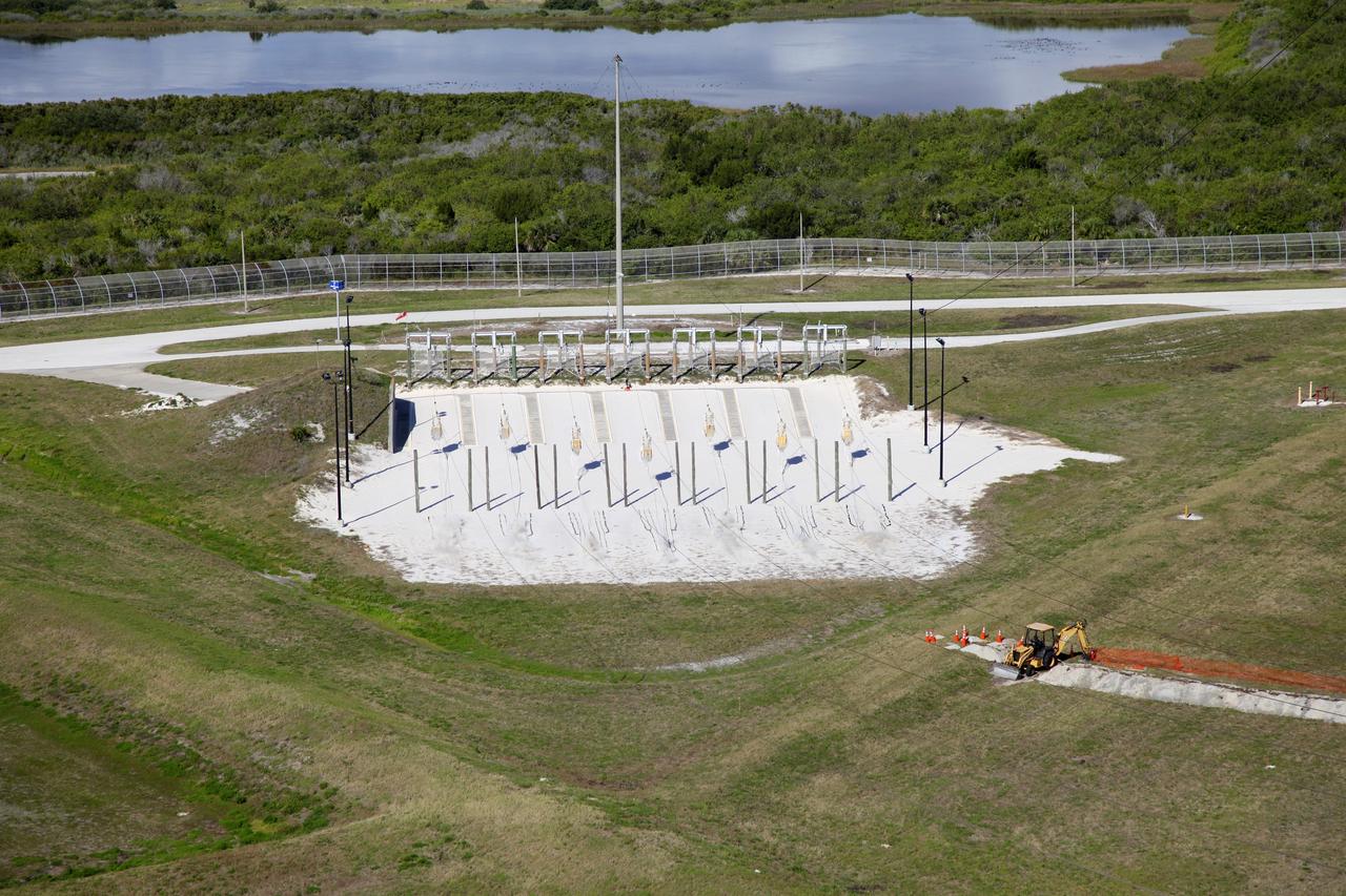 CAPE CANAVERAL, Fla. – At Launch Pad 39A at NASA’s Kennedy Space Center in Florida, the seven slidewire baskets have traveled down the wires to the ground after technicians released them from the 195-foot level for the final time. The baskets will be removed and put in storage.    The system of seven slidewire baskets at launch pads A and B provided an escape route for personnel inside the orbiter or on the orbiter access arm. The baskets are suspended from slidewires that extend from the pad’s Fixed Service Structure to a landing zone 1,200 feet to the west. Each basket could hold up to three people. A braking system catch net and drag chain slowed and then halted the baskets sliding down the wire approximately 55 miles per hour in about half a minute. Photo credit: NASA/Frankie Martin