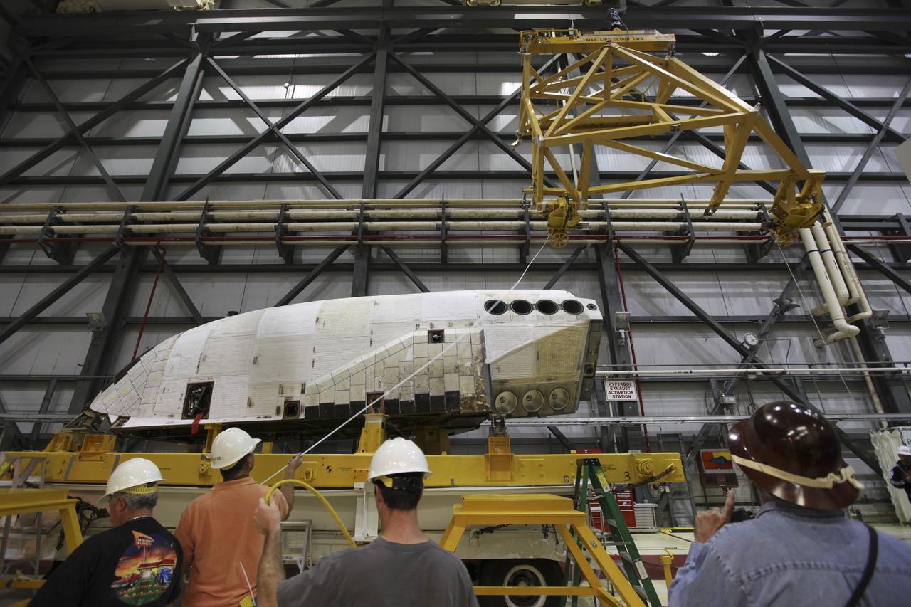 CAPE CANAVERAL, Fla. -- In Orbiter Processing Facility-2 at NASA's Kennedy Space Center in Florida, United Space Alliance technicians prepare to install the left orbital maneuvering system OMS pod on space shuttle Endeavour. The OMS pod underwent complete deservicing and cleaning at White Sands Space Harbor in New Mexico, part of the transition and retirement processing of each shuttle. Endeavour is being prepared for public display at the California Science Center in Los Angeles. Over the course of its 19-year career, Endeavour spent 299 days in space during 25 missions. For more information, visit http://www.nasa.gov/shuttle. Photo credit: NASA/Dimitri Gerondidakis