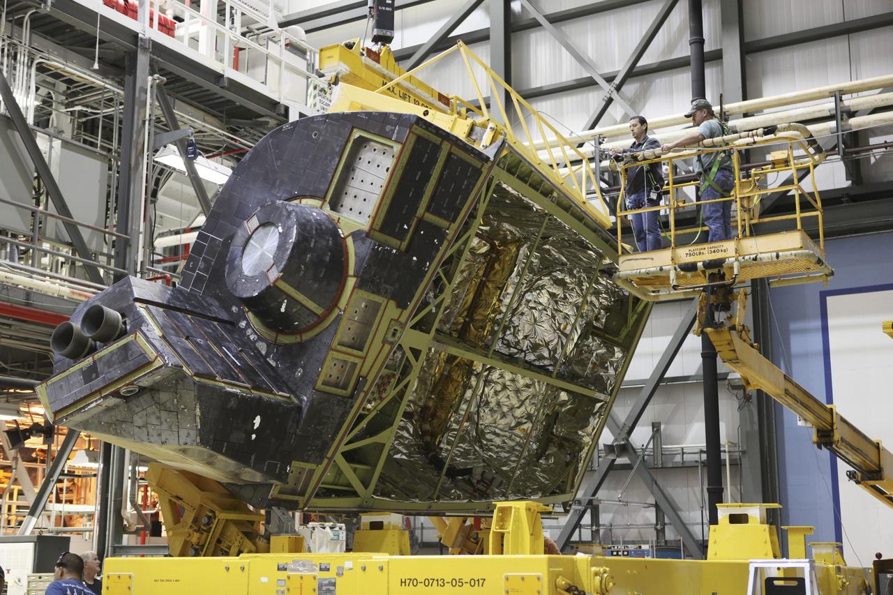 CAPE CANAVERAL, Fla. -- In Orbiter Processing Facility-2 at NASA's Kennedy Space Center in Florida, United Space Alliance technicians rotate the left orbital maneuvering system OMS pod of space shuttle Endeavour as it is lifted from its transporter. The OMS pod is being reinstalled on Endeavour following a complete deservicing and cleaning at White Sands Space Harbor in New Mexico, part of the shuttle’s transition and retirement processing. Endeavour is being prepared for public display at the California Science Center in Los Angeles. Over the course of its 19-year career, Endeavour spent 299 days in space during 25 missions. For more information, visit http://www.nasa.gov/shuttle. Photo credit: NASA/Dimitri Gerondidakis