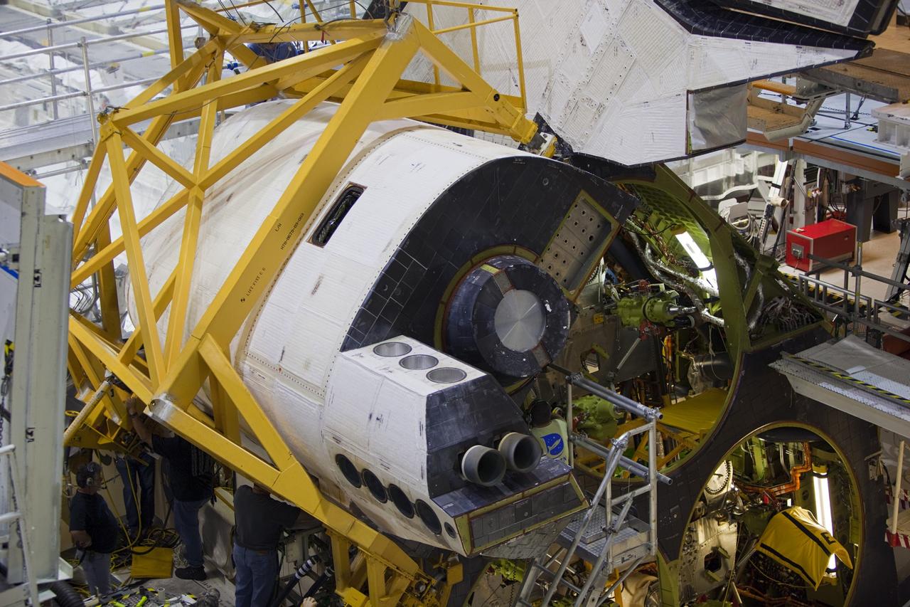 CAPE CANAVERAL, Fla. -- In Orbiter Processing Facility-2 at NASA’s Kennedy Space Center in Florida, United Space Alliance technicians help to install space shuttle Endeavour’s left orbital maneuvering system OMS pod. The OMS pod underwent complete deservicing and cleaning at White Sands Space Harbor in New Mexico, part of the transition and retirement processing of each shuttle. Endeavour is being prepared for public display at the California Science Center in Los Angeles. Over the course of its 19-year career, Endeavour spent 299 days in space during 25 missions. For more information, visit http://www.nasa.gov/shuttle. Photo credit: NASA/Dimitri Gerondidakis