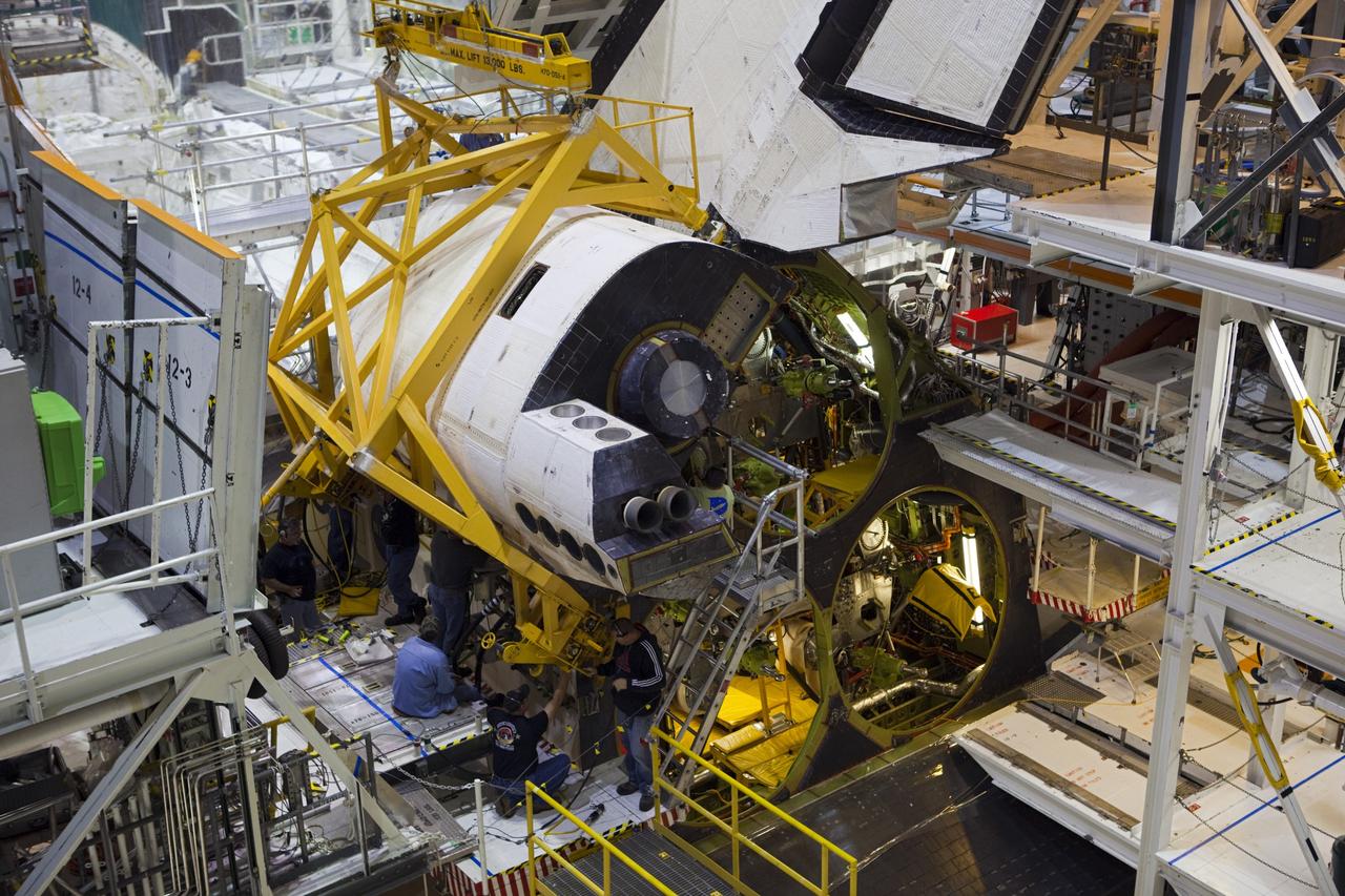 CAPE CANAVERAL, Fla. -- In Orbiter Processing Facility-2 at NASA’s Kennedy Space Center in Florida, United Space Alliance technicians help to install space shuttle Endeavour’s left orbital maneuvering system OMS pod. The OMS pod underwent complete deservicing and cleaning at White Sands Space Harbor in New Mexico, part of the transition and retirement processing of each shuttle. Endeavour is being prepared for public display at the California Science Center in Los Angeles. Over the course of its 19-year career, Endeavour spent 299 days in space during 25 missions. For more information, visit http://www.nasa.gov/shuttle. Photo credit: NASA/Dimitri Gerondidakis