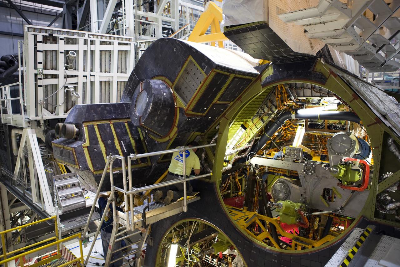 CAPE CANAVERAL, Fla. -- In Orbiter Processing Facility-2 at NASA’s Kennedy Space Center in Florida, United Space Alliance technicians help to install space shuttle Endeavour’s left orbital maneuvering system OMS pod. The OMS pod underwent complete deservicing and cleaning at White Sands Space Harbor in New Mexico, part of the transition and retirement processing of each shuttle. Endeavour is being prepared for public display at the California Science Center in Los Angeles. Over the course of its 19-year career, Endeavour spent 299 days in space during 25 missions. For more information, visit http://www.nasa.gov/shuttle. Photo credit: NASA/Dimitri Gerondidakis