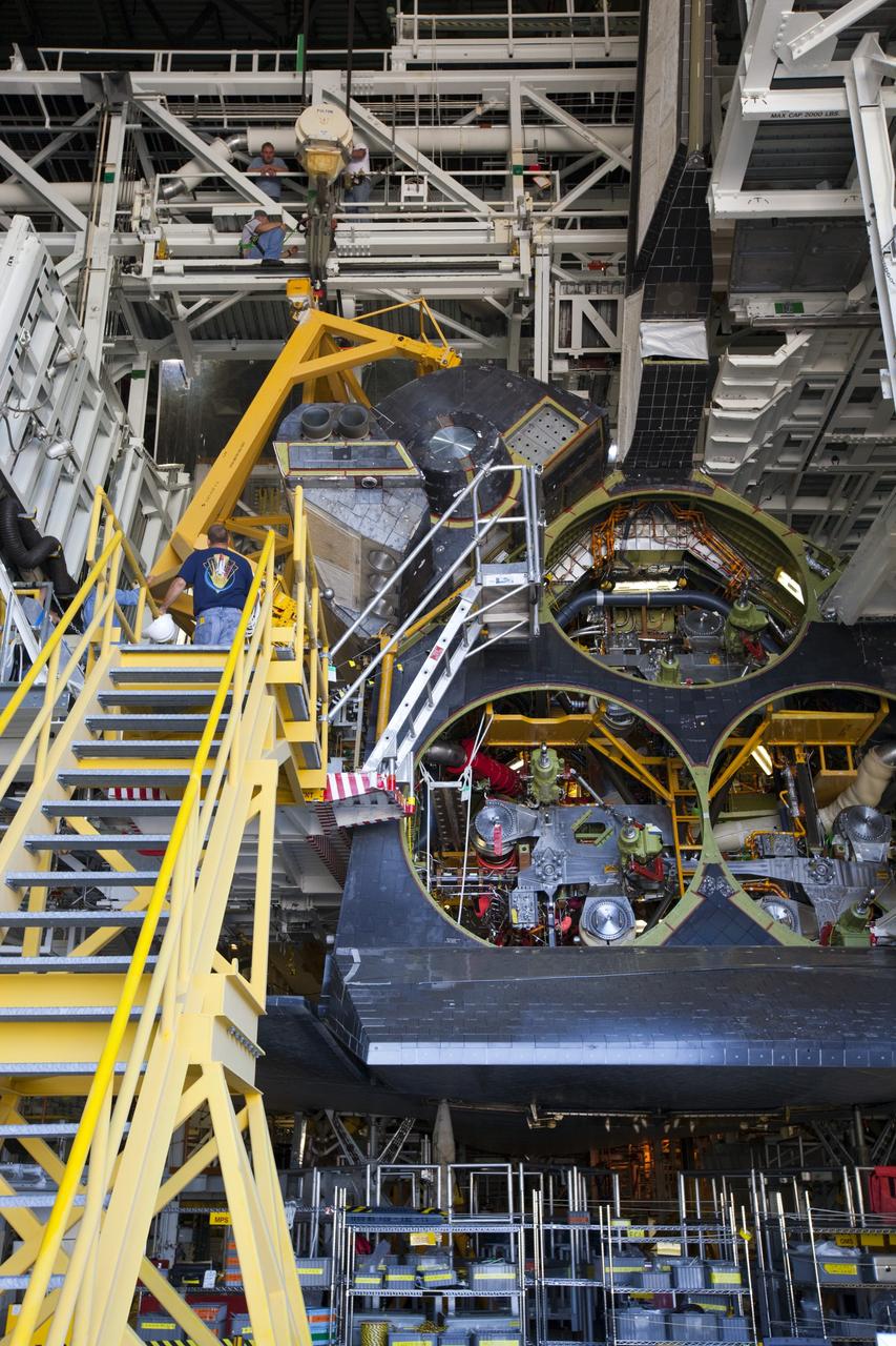 CAPE CANAVERAL, Fla. -- In Orbiter Processing Facility-2 at NASA’s Kennedy Space Center in Florida, a large crane lowers the left orbital maneuvering system OMS pod on to space shuttle Endeavour so that United Space Alliance technicians can complete the installation. The OMS pod underwent complete deservicing and cleaning at White Sands Space Harbor in New Mexico, part of the transition and retirement processing of each shuttle. Endeavour is being prepared for public display at the California Science Center in Los Angeles. Over the course of its 19-year career, Endeavour spent 299 days in space during 25 missions. For more information, visit http://www.nasa.gov/shuttle. Photo credit: NASA/Dimitri Gerondidakis
