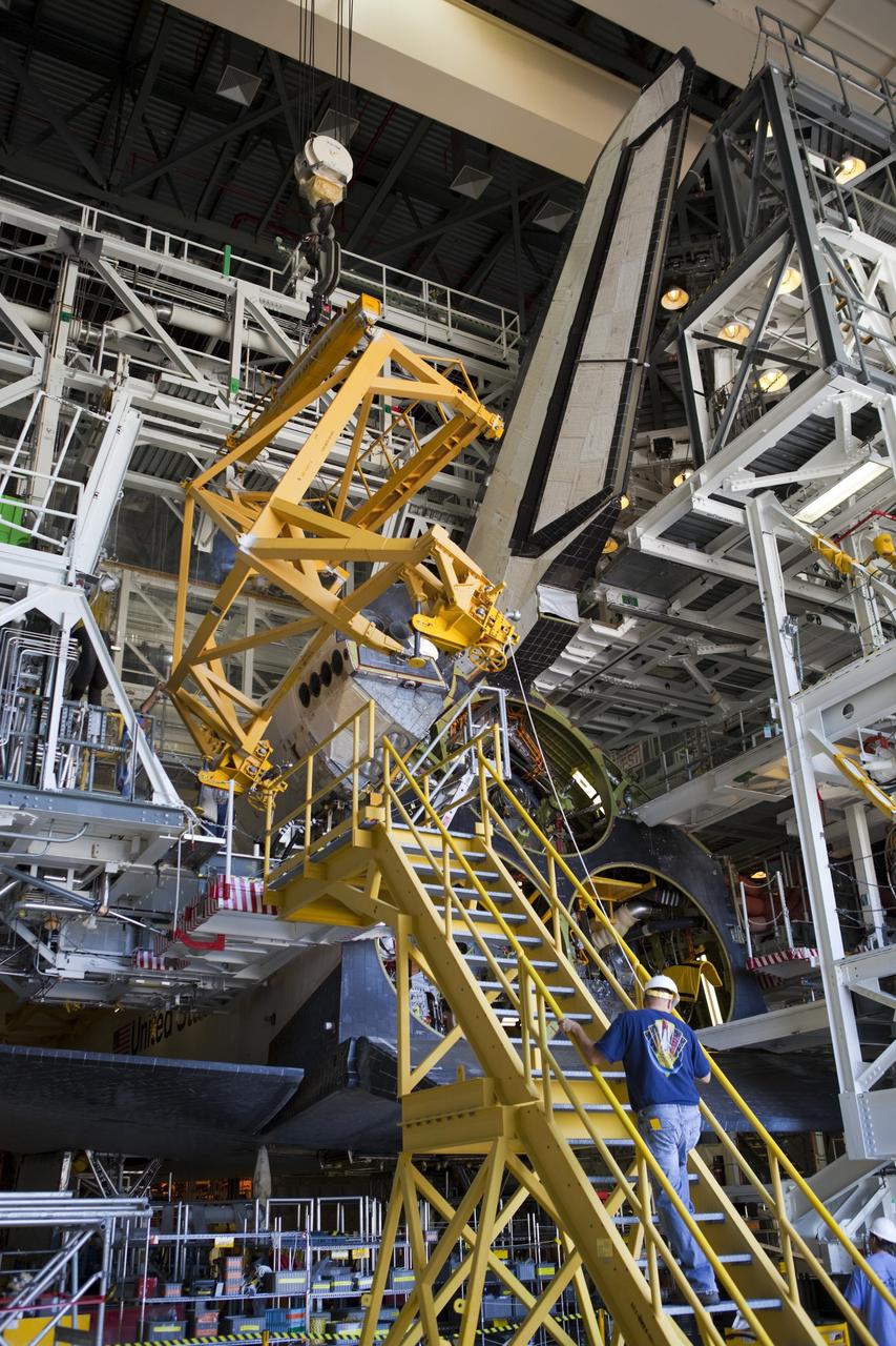 CAPE CANAVERAL, Fla. -- In Orbiter Processing Facility-2 at NASA’s Kennedy Space Center in Florida, a large crane lowers the left orbital maneuvering system OMS pod on to space shuttle Endeavour so that United Space Alliance technicians can complete the installation. The OMS pod underwent complete deservicing and cleaning at White Sands Space Harbor in New Mexico, part of the transition and retirement processing of each shuttle. Endeavour is being prepared for public display at the California Science Center in Los Angeles. Over the course of its 19-year career, Endeavour spent 299 days in space during 25 missions. For more information, visit http://www.nasa.gov/shuttle. Photo credit: NASA/Dimitri Gerondidakis