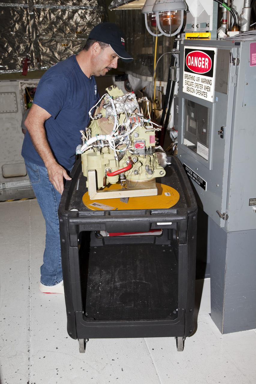 CAPE CANAVERAL, Fla. -- In Orbiter Processing Facility-2 at NASA’s Kennedy Space Center in Florida, a United Space Alliance technician begins to move a cart containing one of the auxiliary power units that was removed from space shuttle Endeavour. The work is part of Endeavour’s transition and retirement processing. The spacecraft is being prepared for public display at the California Science Center in Los Angeles. Endeavour flew 25 missions, spent 299 days in space, orbited Earth 4,671 times and traveled 122, 883, 151 miles over the course of its 19-year career. For more information, visit http://www.nasa.gov/shuttle. Photo credit: NASA/Dimitri Gerondidakis