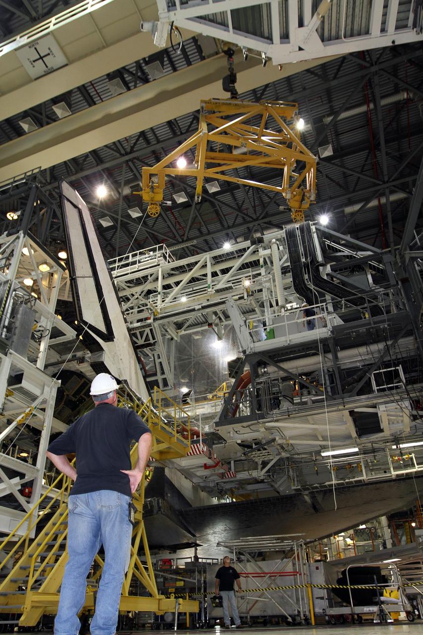 CAPE CANAVERAL, Fla. – In Orbiter Processing Facility-2 at NASA’s Kennedy Space Center in Florida, United Space Alliance technicians monitor the progress as a large crane is prepared to lift the right orbital maneuvering system OMS pod for installation on space shuttle Endeavour. The OMS pod underwent complete deservicing and cleaning at White Sands Space Harbor in New Mexico, part of the transition and retirement processing of each shuttle. Endeavour is being prepared for public display at the California Science Center in Los Angeles. Over the course of its 19-year career, Endeavour spent 299 days in space during 25 missions. For more information, visit http://www.nasa.gov/shuttle. Photo credit: NASA/Kim Shiflett