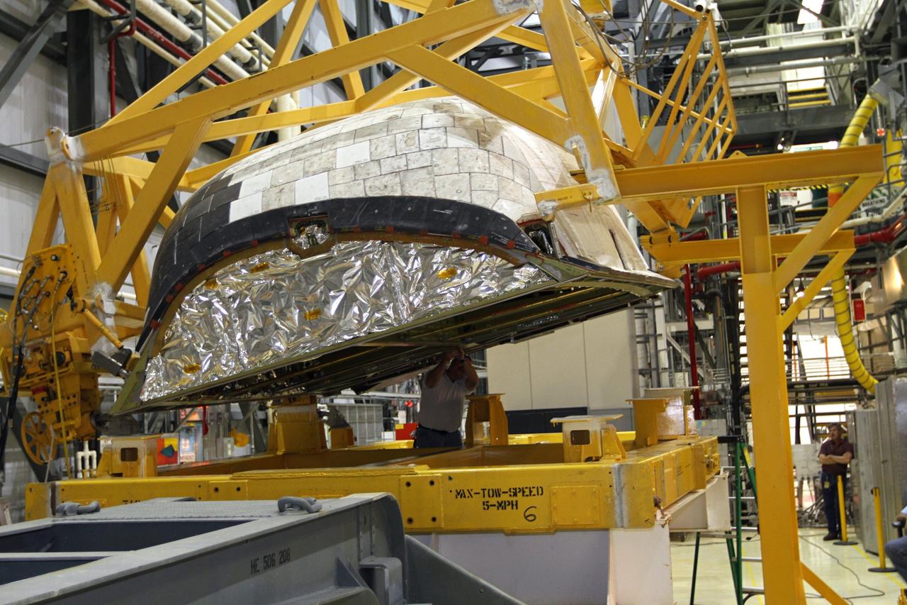 CAPE CANAVERAL, Fla. – In Orbiter Processing Facility-2 at NASA’s Kennedy Space Center in Florida, a large crane is used to lift the right orbital maneuvering system OMS pod that will be installed on space shuttle Endeavour. The OMS pod underwent complete deservicing and cleaning at White Sands Space Harbor in New Mexico, part of the transition and retirement processing of each shuttle. Endeavour is being prepared for public display at the California Science Center in Los Angeles. Over the course of its 19-year career, Endeavour spent 299 days in space during 25 missions. For more information, visit http://www.nasa.gov/shuttle. Photo credit: NASA/Kim Shiflett