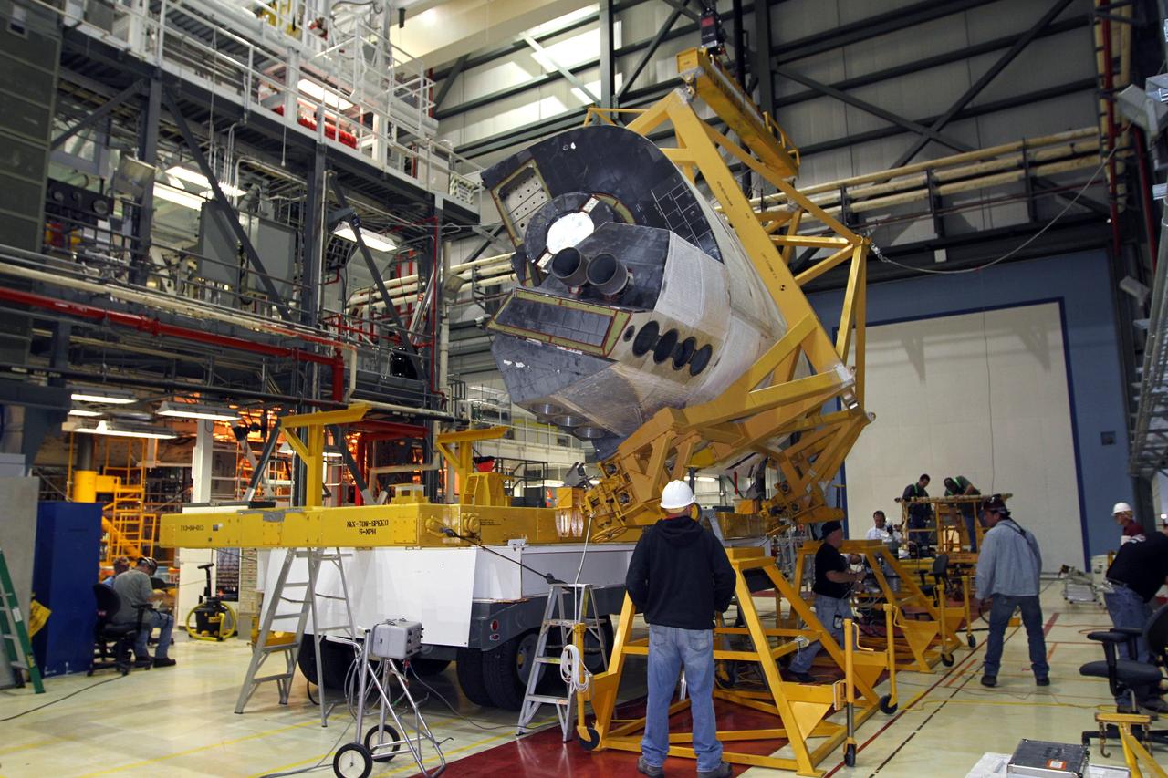 CAPE CANAVERAL, Fla. – In Orbiter Processing Facility-2 at NASA’s Kennedy Space Center in Florida, United Space Alliance technicians monitor the progress as a large crane lifts the right orbital maneuvering system OMS pod for installation on space shuttle Endeavour. The OMS pod underwent complete deservicing and cleaning at White Sands Space Harbor in New Mexico, part of the transition and retirement processing of each shuttle. Endeavour is being prepared for public display at the California Science Center in Los Angeles. Over the course of its 19-year career, Endeavour spent 299 days in space during 25 missions. For more information, visit http://www.nasa.gov/shuttle. Photo credit: NASA/Kim Shiflett