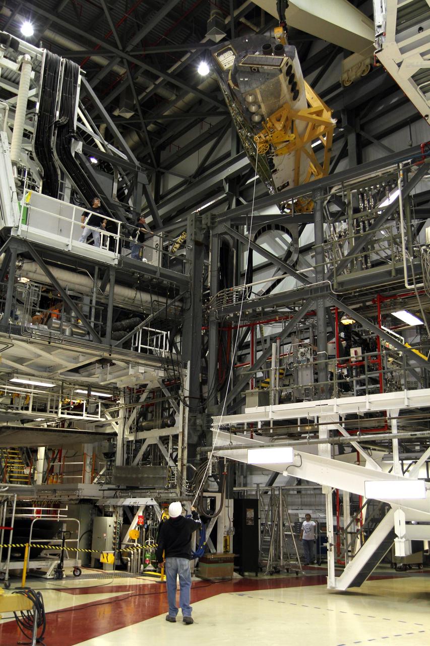 CAPE CANAVERAL, Fla. – In Orbiter Processing Facility-2 at NASA’s Kennedy Space Center in Florida, United Space Alliance technicians monitor the progress as a large crane lifts the right orbital maneuvering system OMS pod high in the air for installation on space shuttle Endeavour. The OMS pod underwent complete deservicing and cleaning at White Sands Space Harbor in New Mexico, part of the transition and retirement processing of each shuttle. Endeavour is being prepared for public display at the California Science Center in Los Angeles. Over the course of its 19-year career, Endeavour spent 299 days in space during 25 missions. For more information, visit http://www.nasa.gov/shuttle. Photo credit: NASA/Kim Shiflett