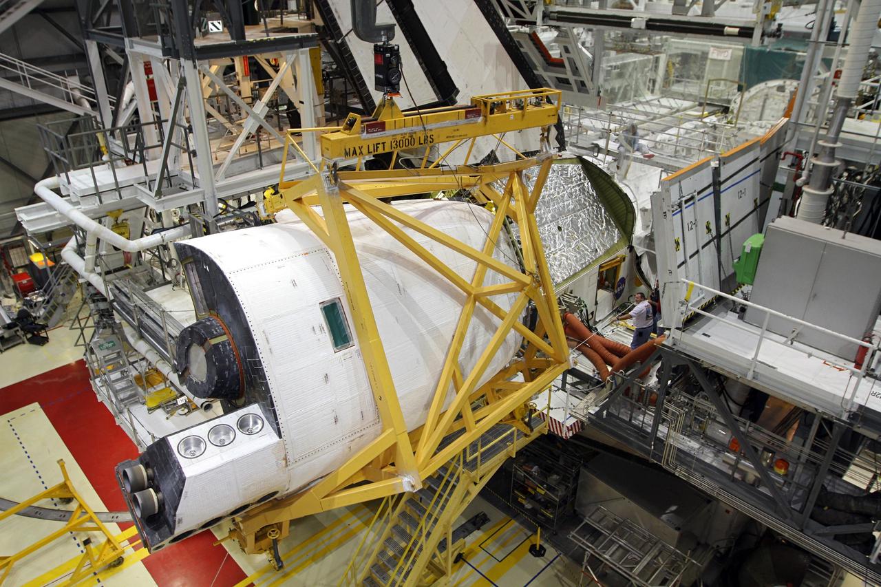 CAPE CANAVERAL, Fla. – In Orbiter Processing Facility-2 at NASA’s Kennedy Space Center in Florida, a large crane moves the right orbital maneuvering system OMS pod closer to space shuttle Endeavour for installation. The OMS pod underwent complete deservicing and cleaning at White Sands Space Harbor in New Mexico, part of the transition and retirement processing of each shuttle. Endeavour is being prepared for public display at the California Science Center in Los Angeles. Over the course of its 19-year career, Endeavour spent 299 days in space during 25 missions. For more information, visit http://www.nasa.gov/shuttle. Photo credit: NASA/Kim Shiflett
